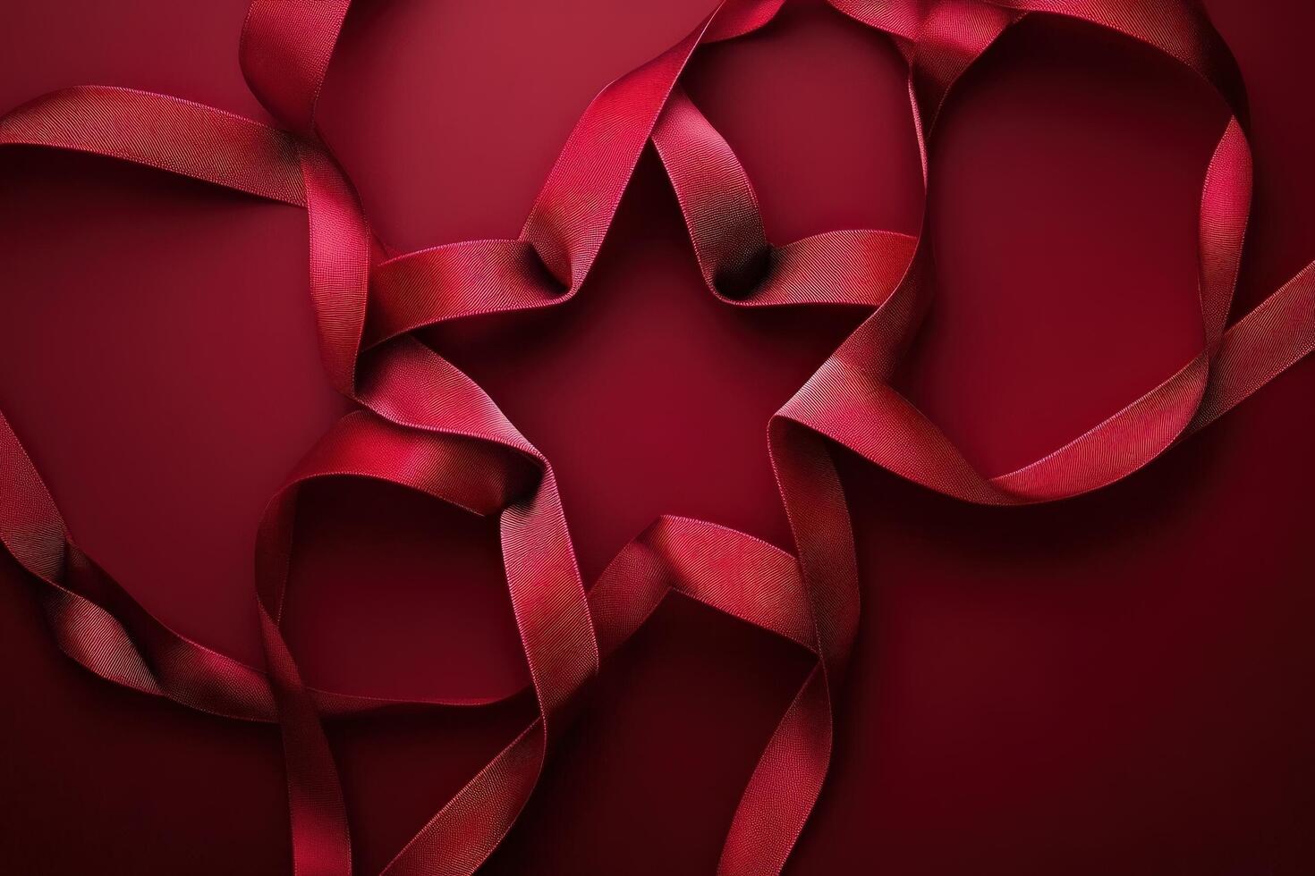 Red ribbon arranged in a star shape on a dark red background photo