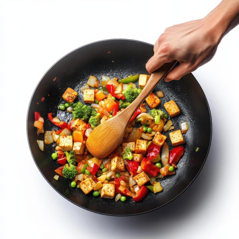 A person holding a wooden spoon over a pan of food photo