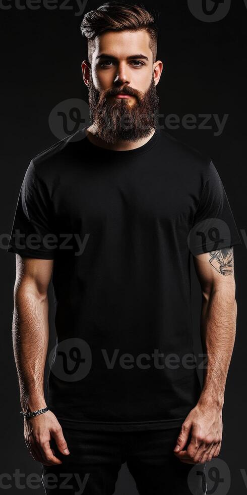 Stylish man in black t-shirt poses against dark background photo
