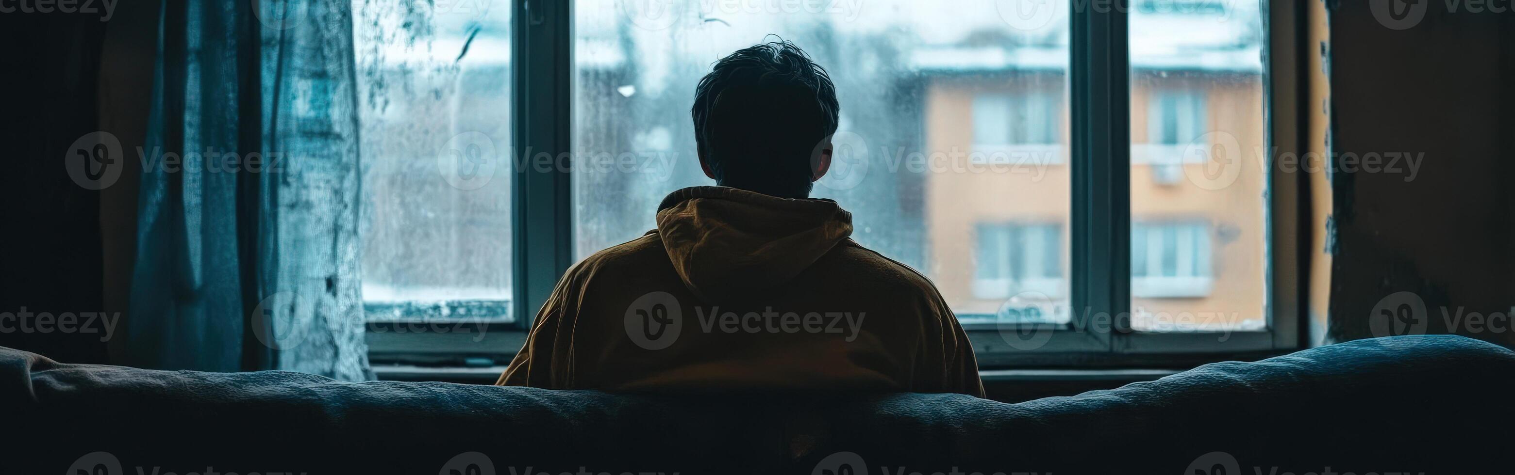 Feeling isolated on a rainy day while watching from the window photo