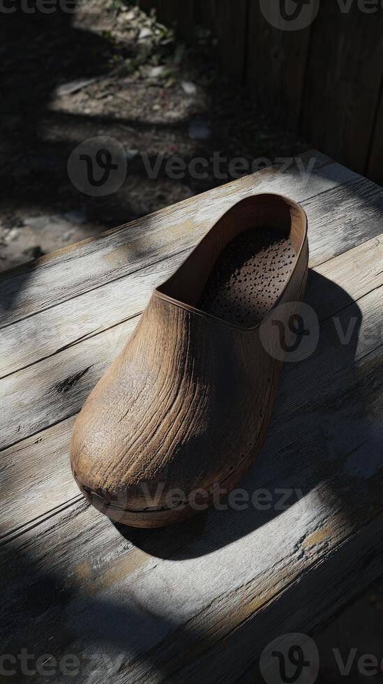 Clogs resting on a rustic wooden surface with natural shadows photo