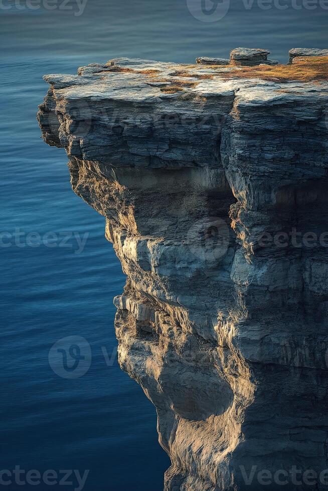 A cliff with a large rock on top of it photo