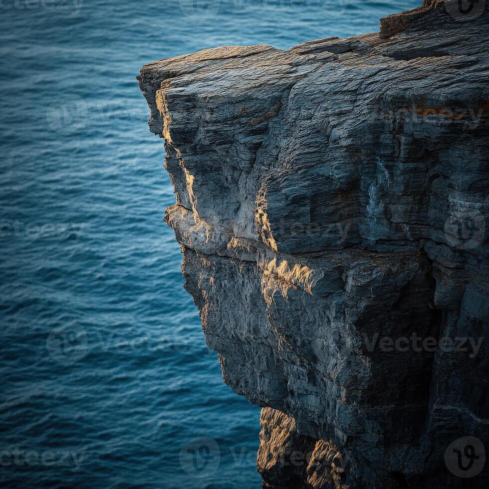 Rugged cliff edge above ocean photo
