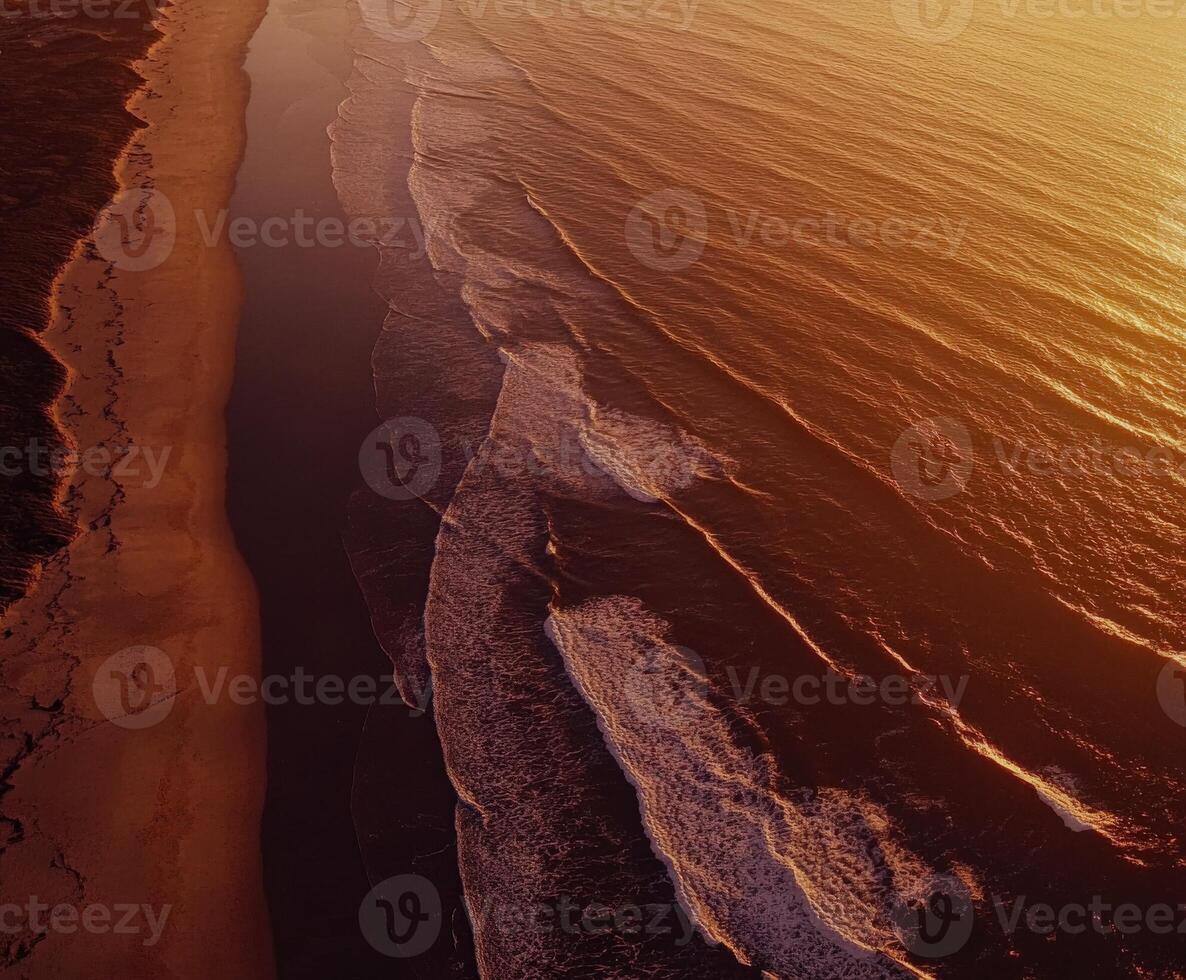 Aerial view of the ocean and beach at sunset photo