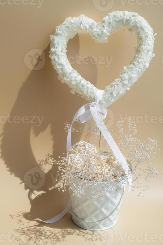 White lilac flowers heart shaped decor for present gift in pastel backdrop. Symbol of love floral arrangement. Spring concept idea Valentine's Day, weeding proposal postcard copy space for your text photo