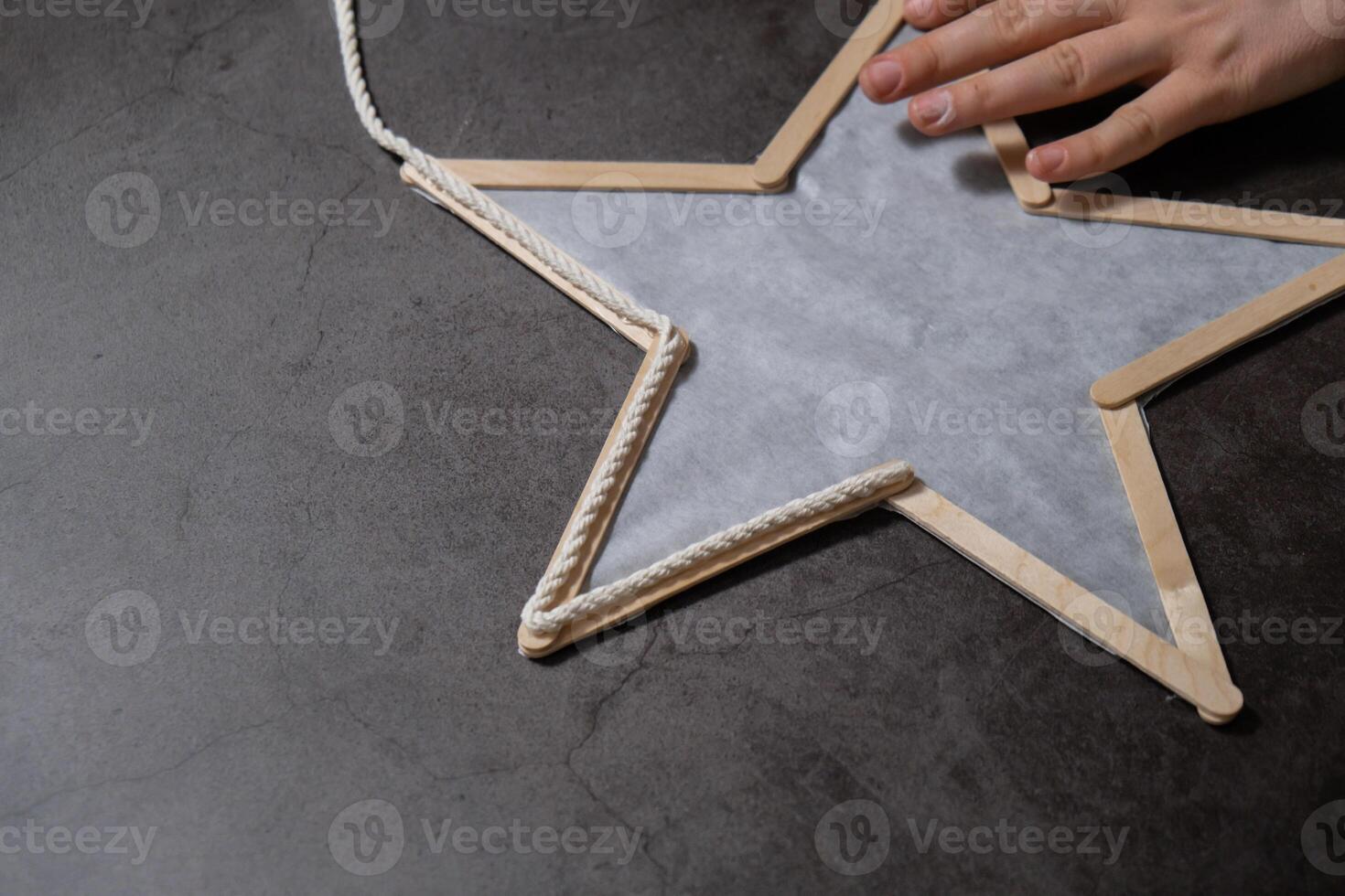 Christmas star made of ice cream sticks. Gift idea. Do it yourself instruction eco-friendly decoration. Zero waste Making handmade presents children's diy projects. Holiday family time. Creative activity photo