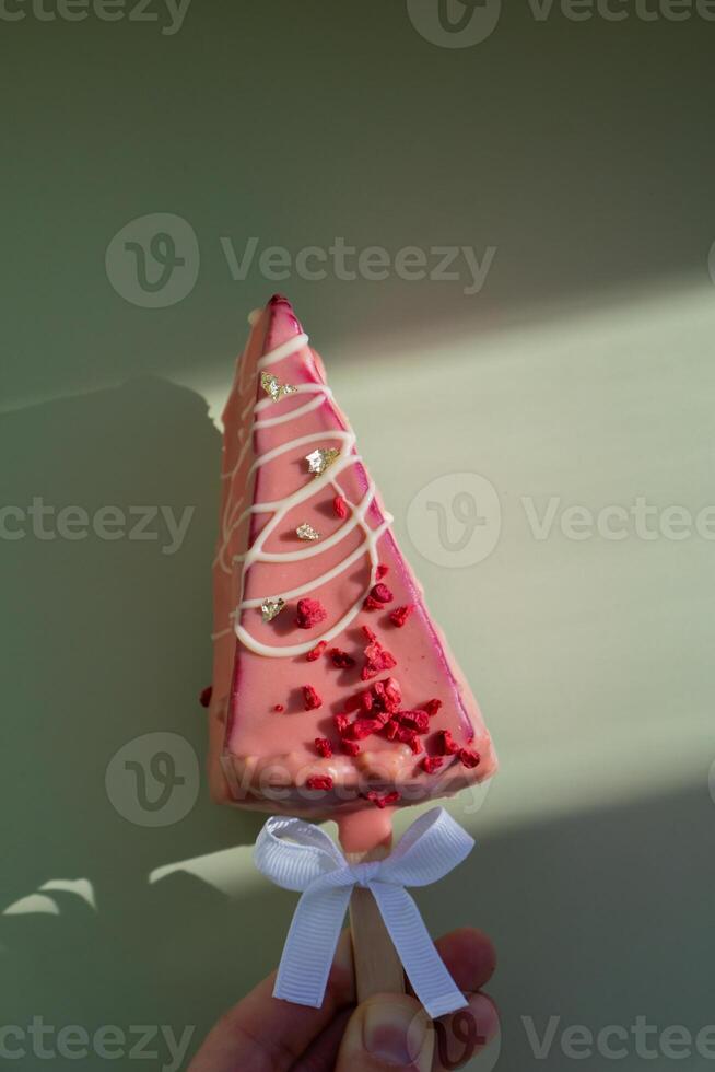 New look of trendy miniature ice cream cheesecake on stick in vibrant pink color on pastel background. Copy space mock up template sample for bakery mini dessert coffee shop. Cake to go takeaway sweet holiday gift idea one person photo