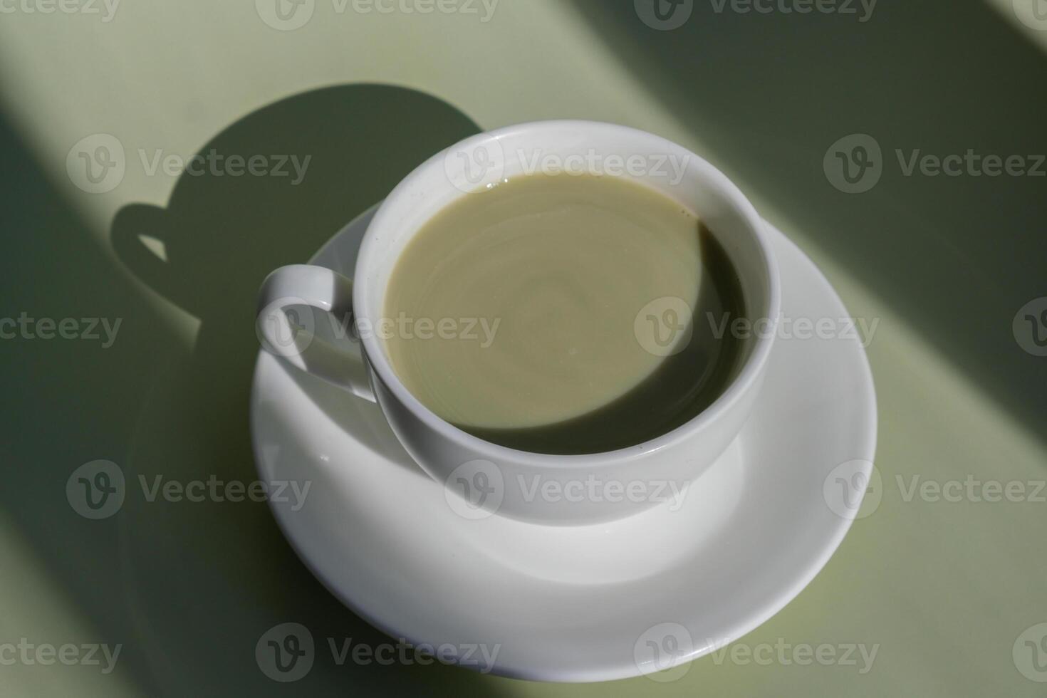 Nutrient-rich matcha drink with trendy deep shadows on soft colored background. Morning beautiful breakfast present gift idea. Vibrant creative colors. Natural energy givers tea photo