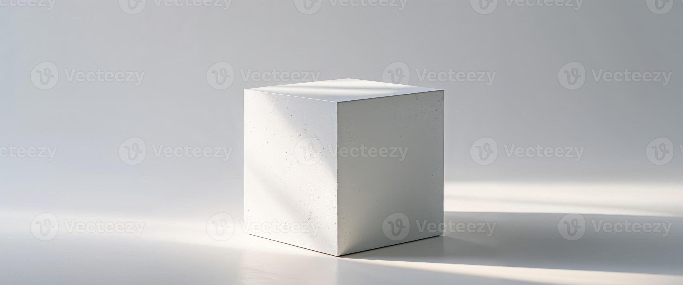 White cube bathed in light with textured surface stands still. photo