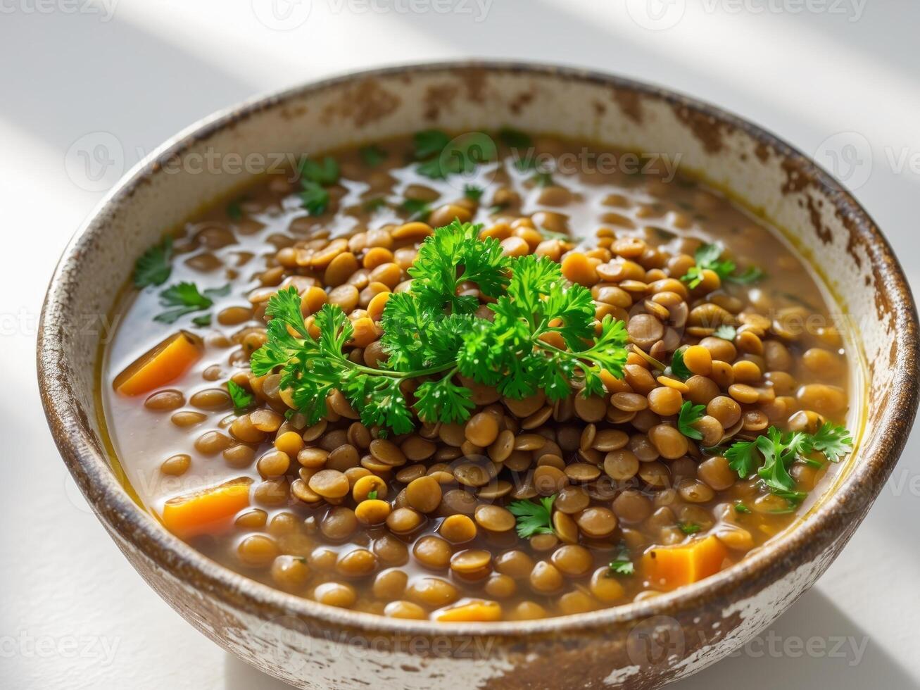 Hearty lentil soup topped with fresh parsley in a rustic bowl photo