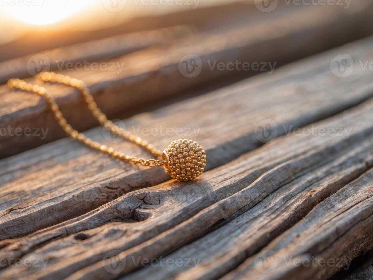 A gold ball necklace on a wooden table photo
