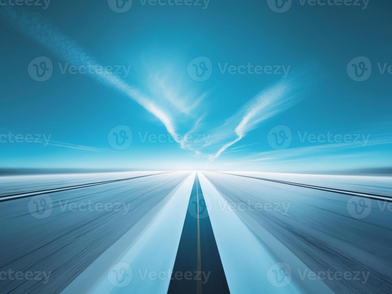 An empty road with a blue sky and clouds in the background photo