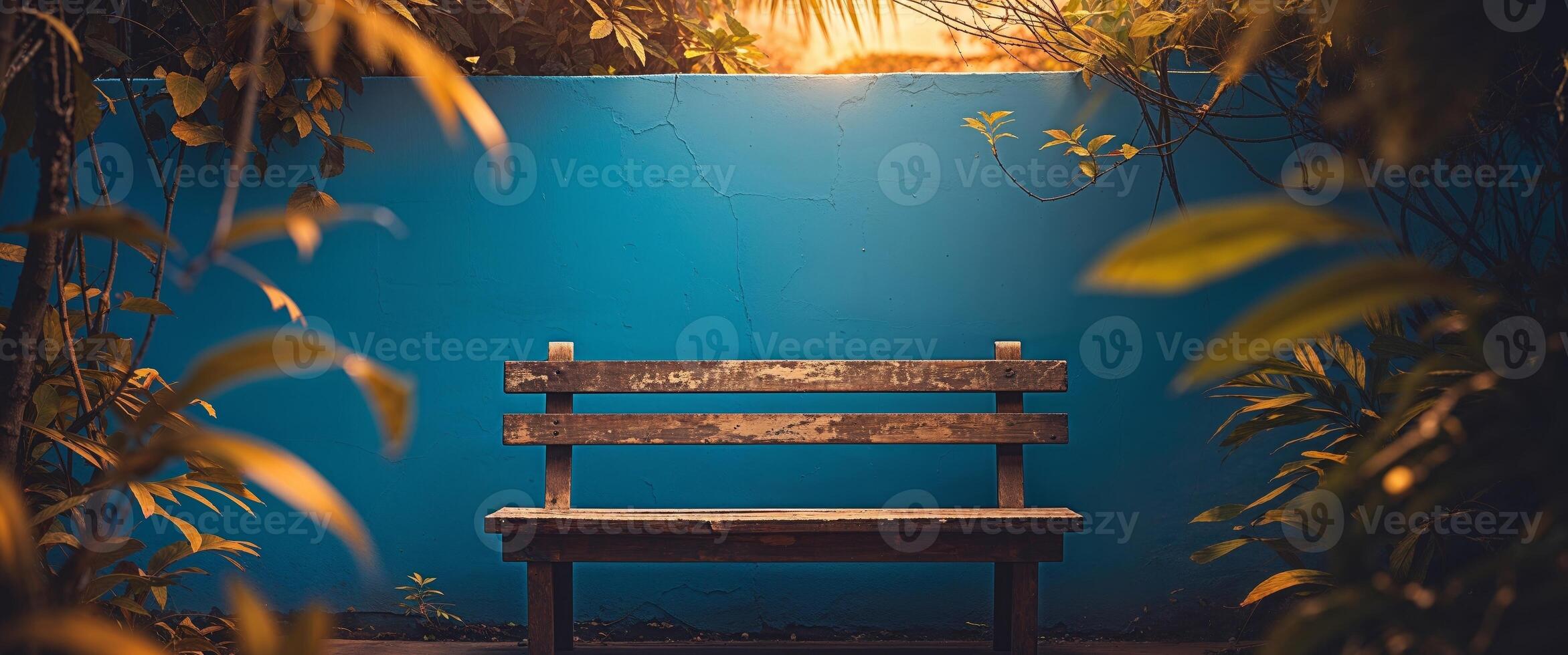 A wooden bench sitting in the middle of a blue wall photo