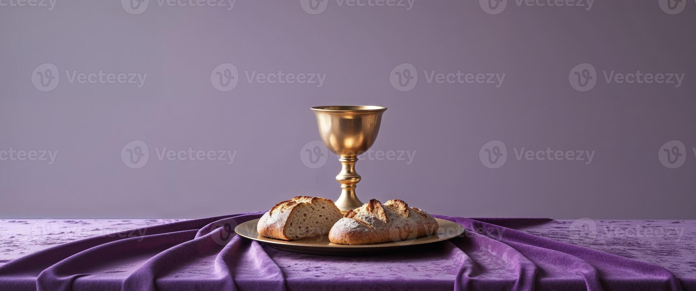 A golden chalice and bread on a purple cloth photo