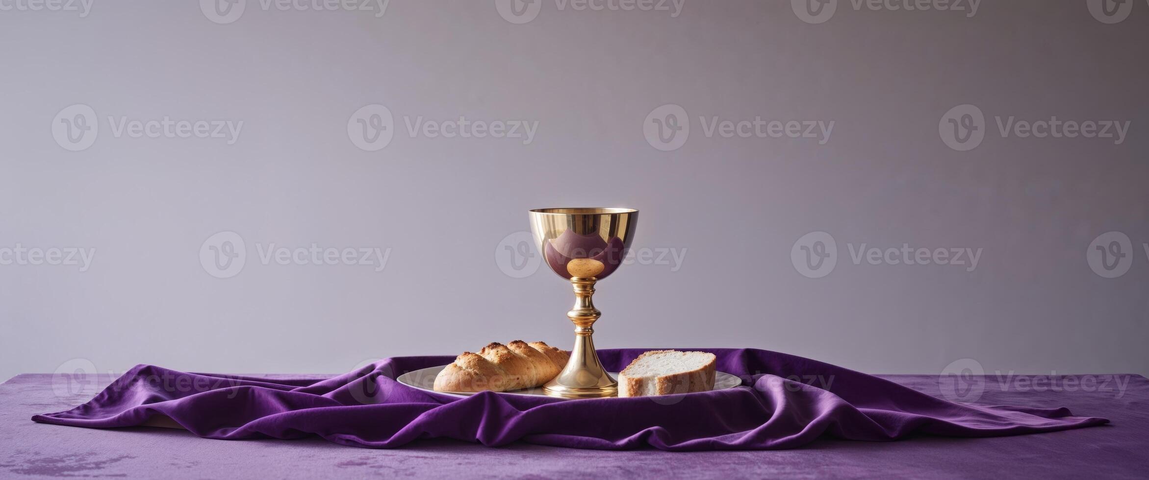 Holy Communion Chalice and Bread on Purple Cloth. photo