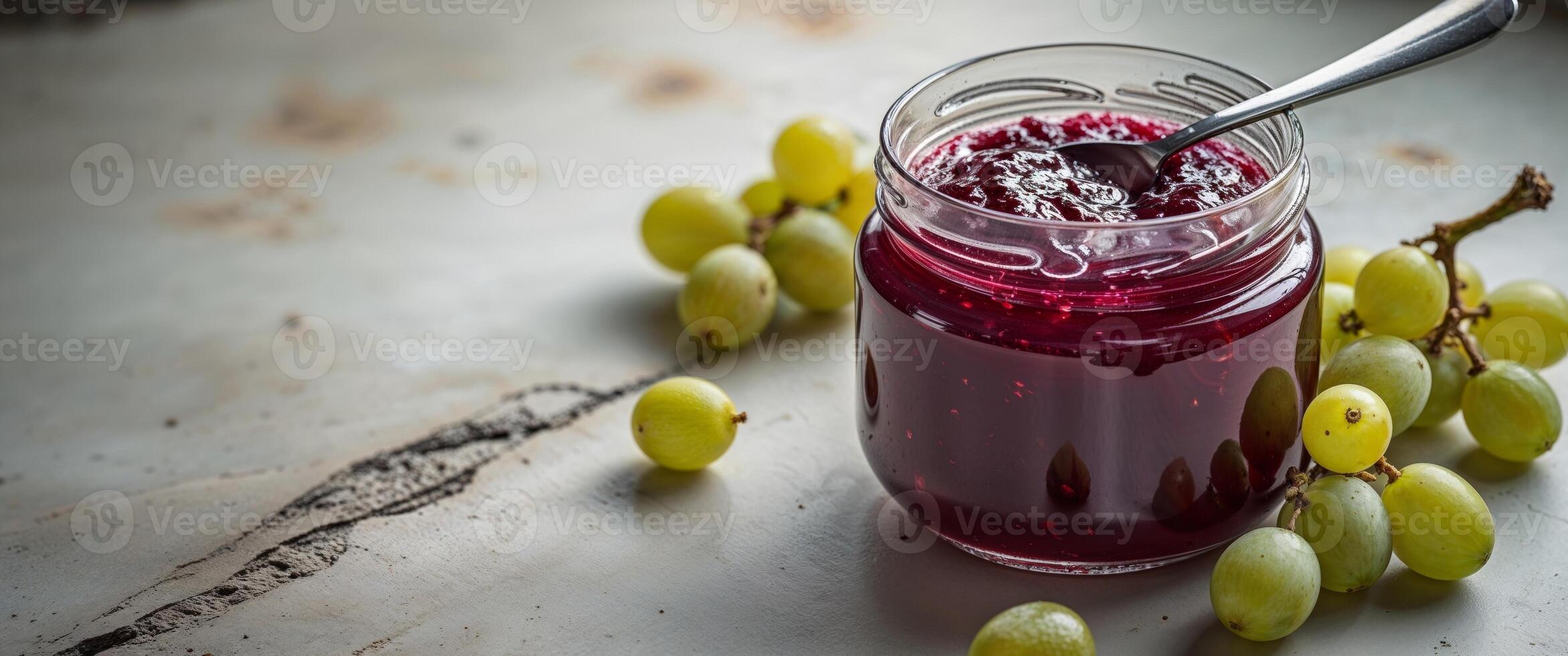 A jar of jam with grapes and a spoon photo
