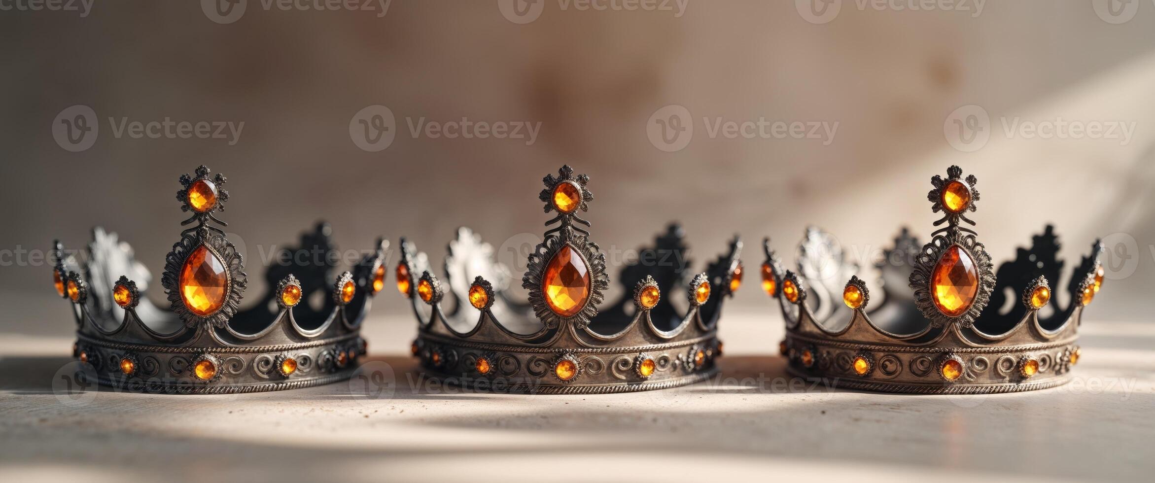 Three Ornate Crowns with Glowing Amber Jewels photo