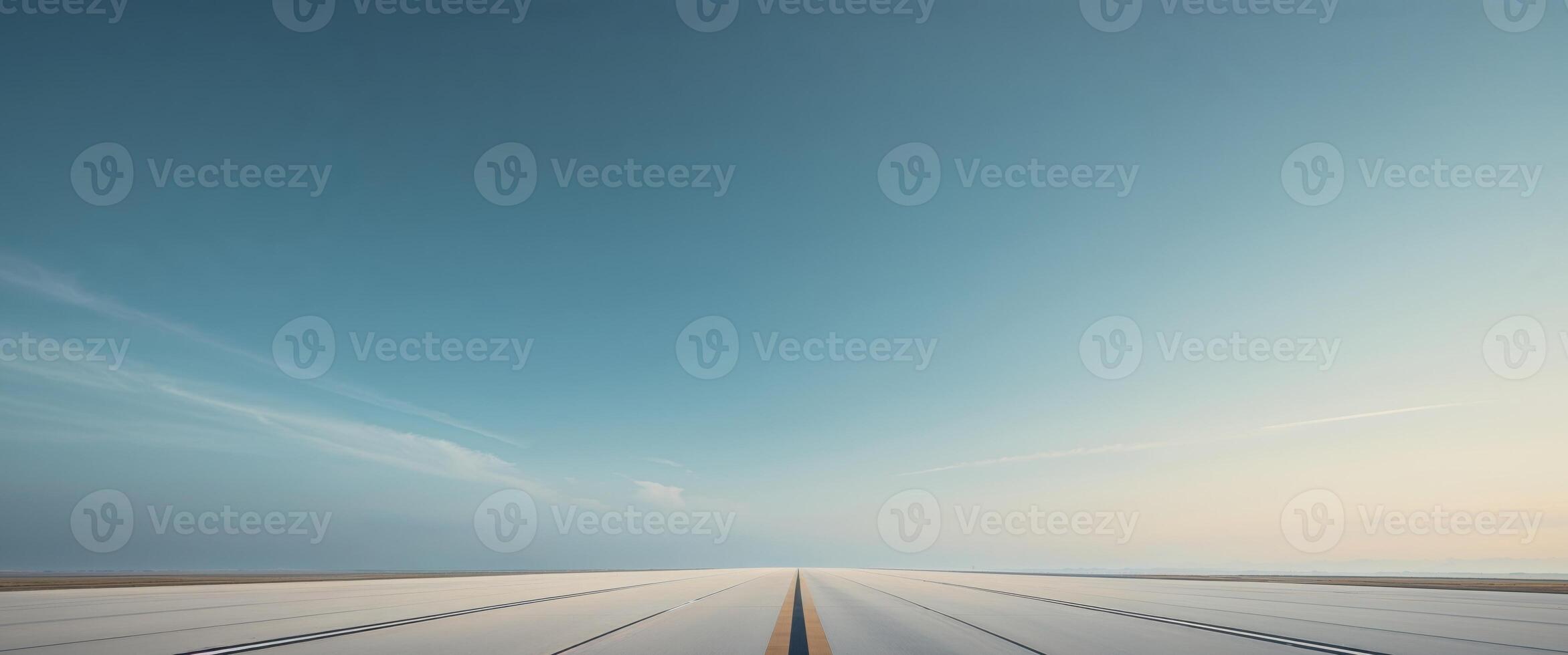 Long empty runway stretching into the horizon under a clear blue sky. photo