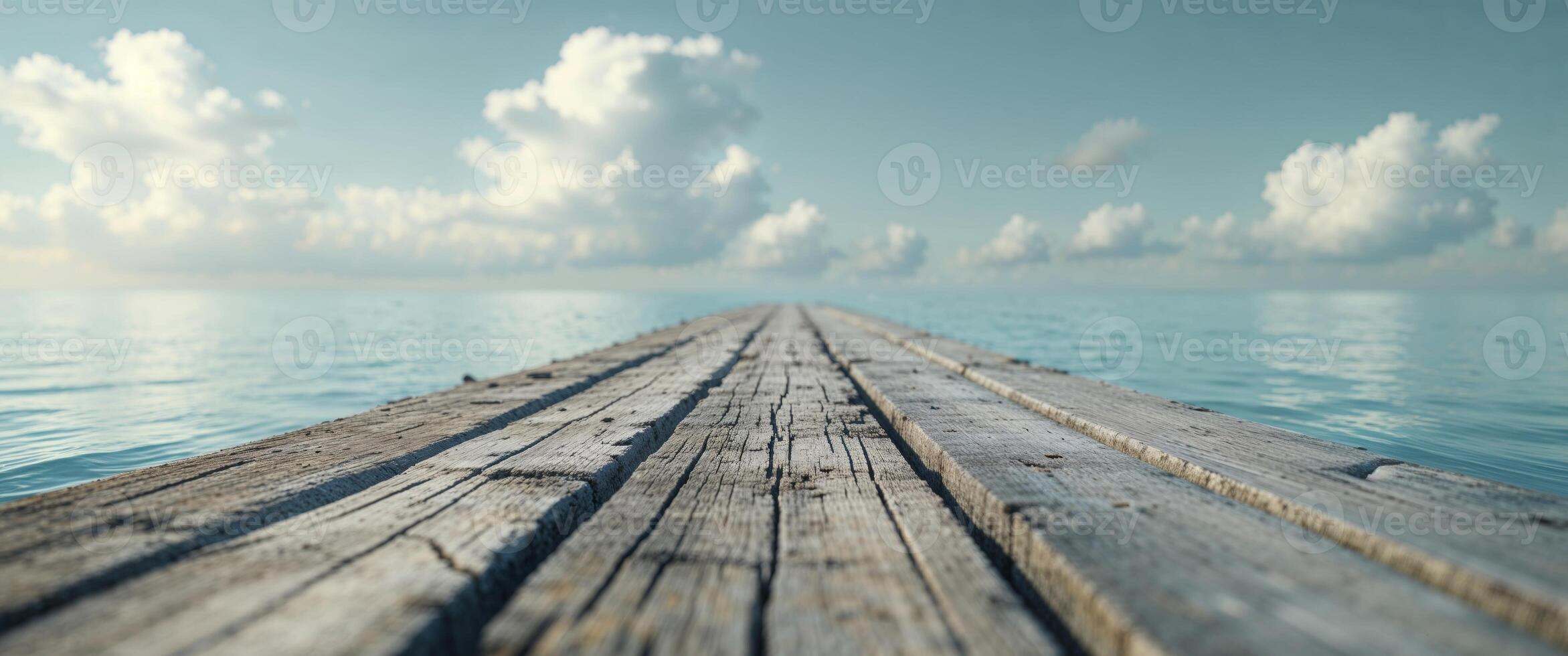 A wooden pier over the ocean with clouds in the sky photo