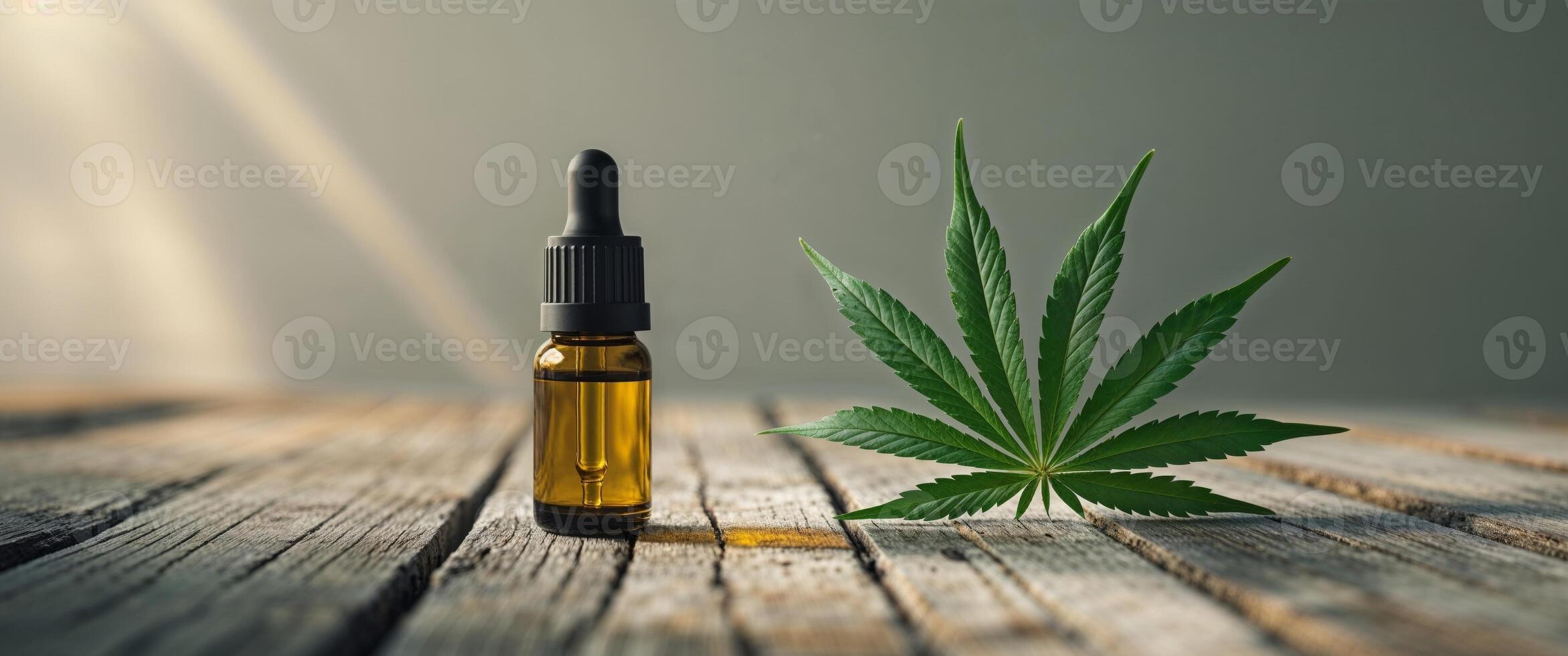 Cbd oil and cannabis leaf on wooden table photo