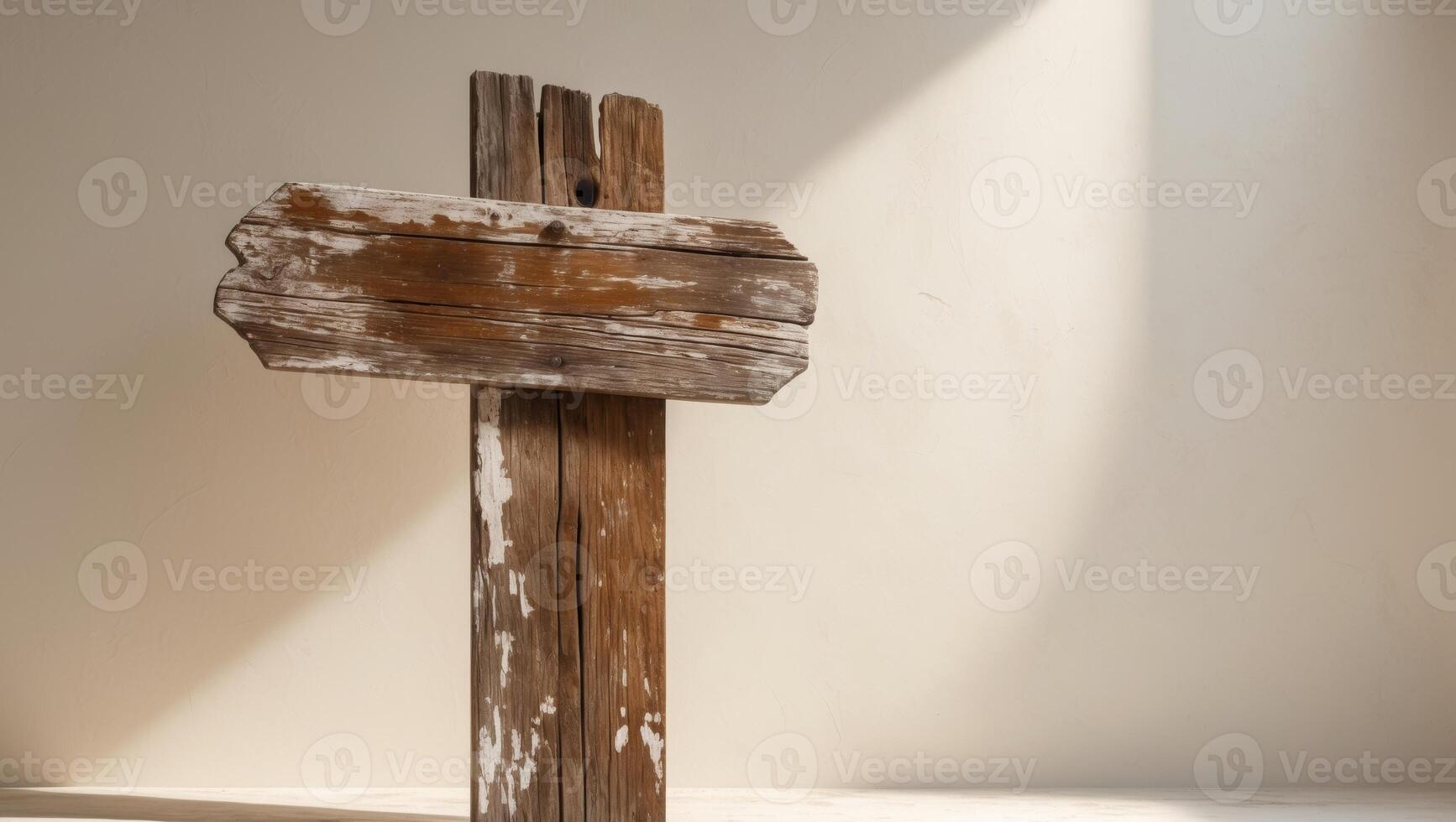 An old wooden cross is standing in front of a wall photo