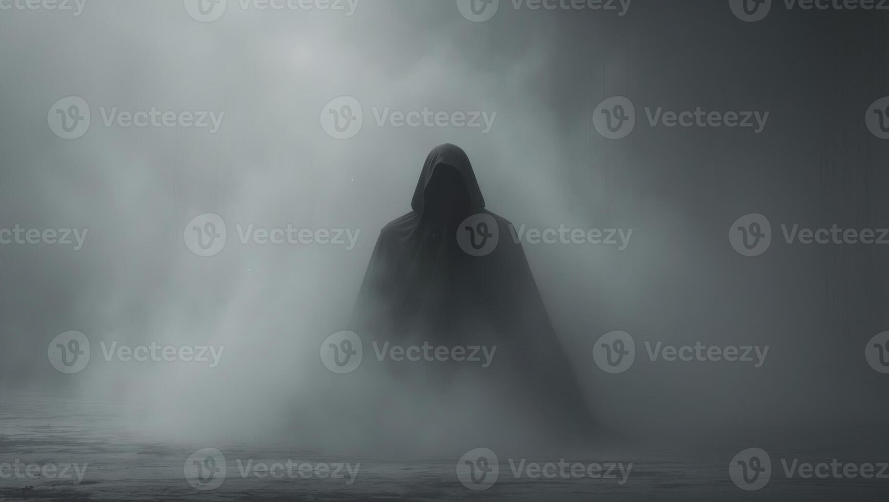 A person in a hooded robe standing in the fog photo