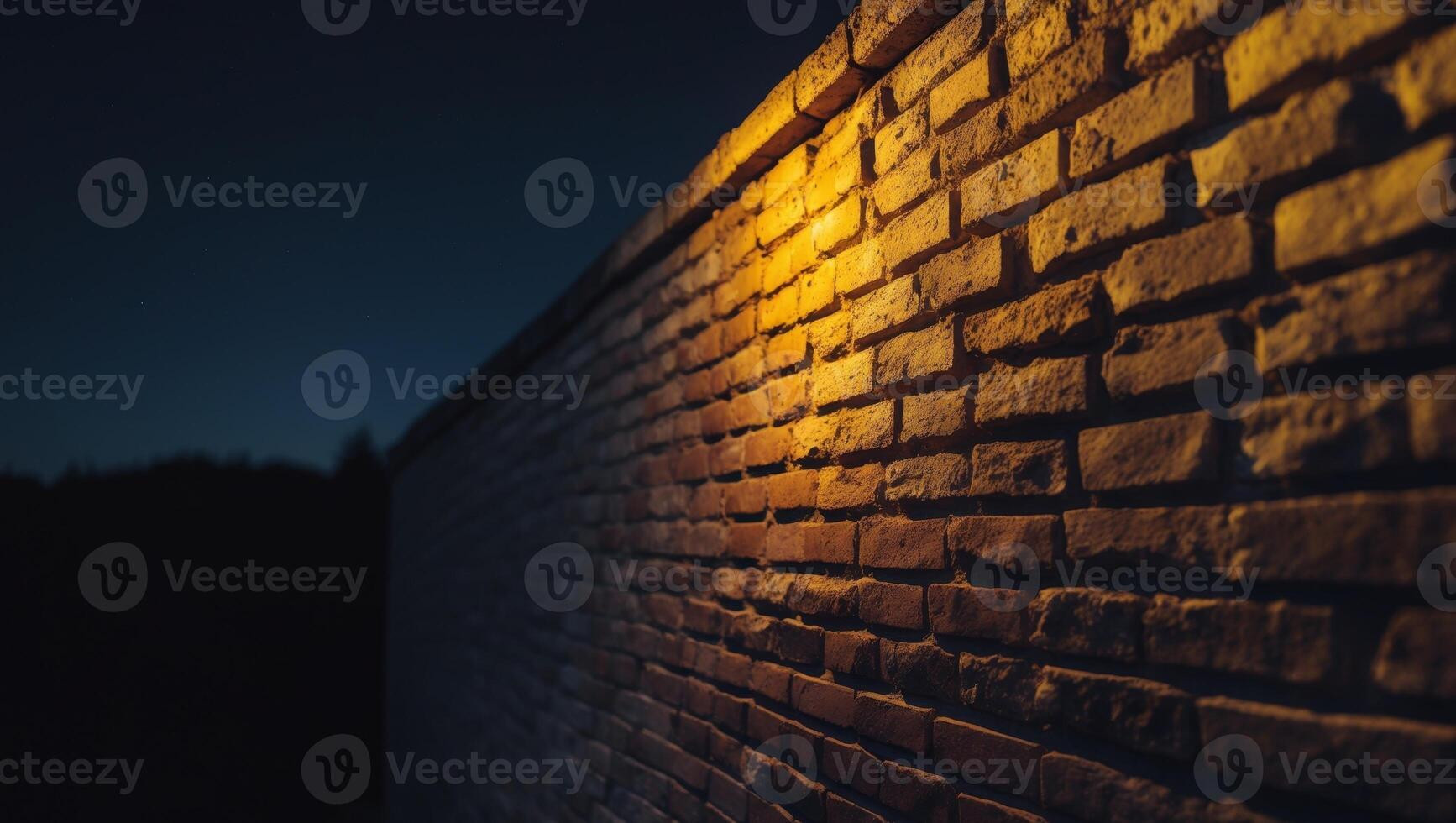 A brick wall with a light shining on it at night photo