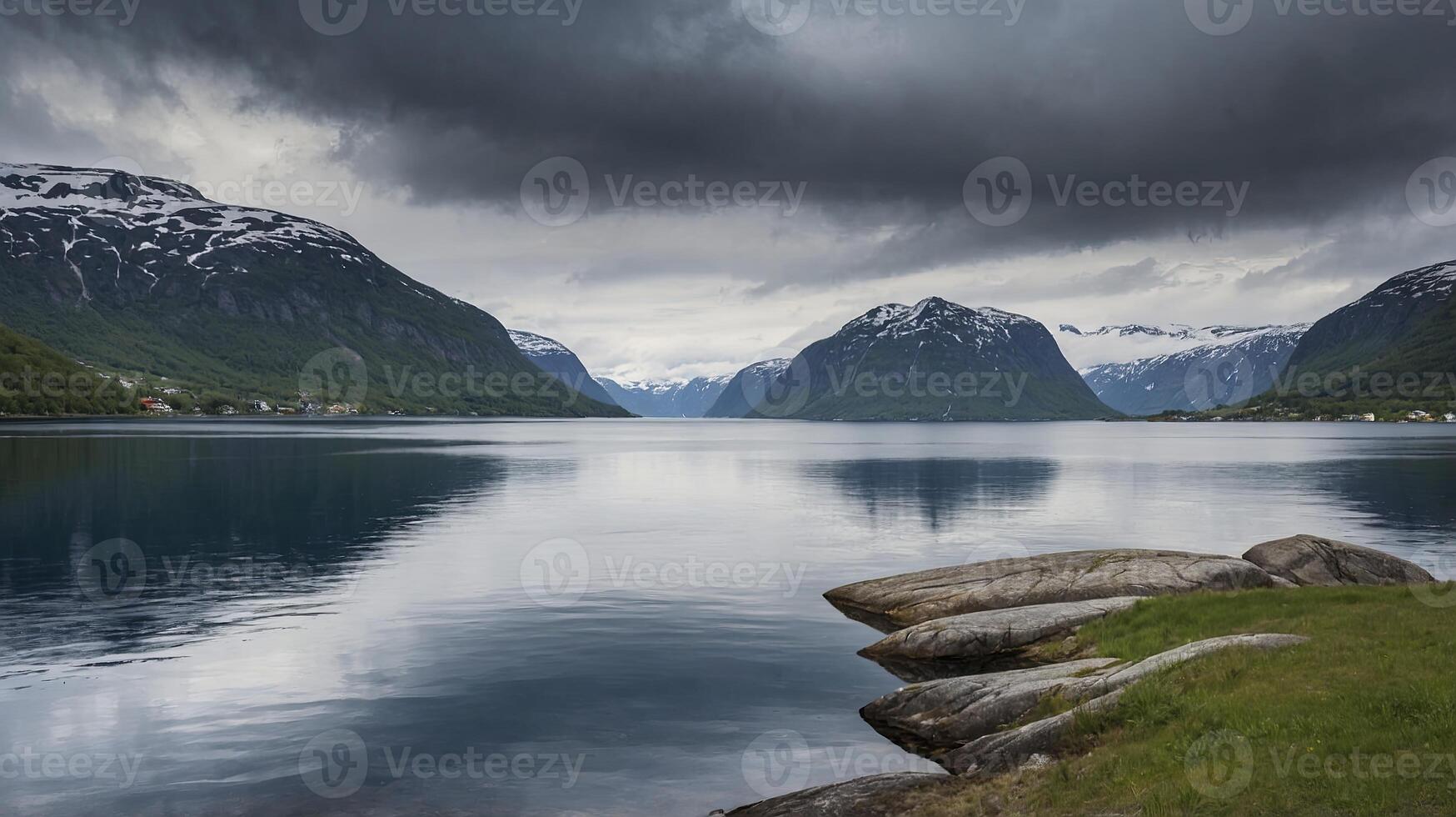 Calm Lake Surrounded by Mountains Under Dramatic Cloudy Sky Landscape photo