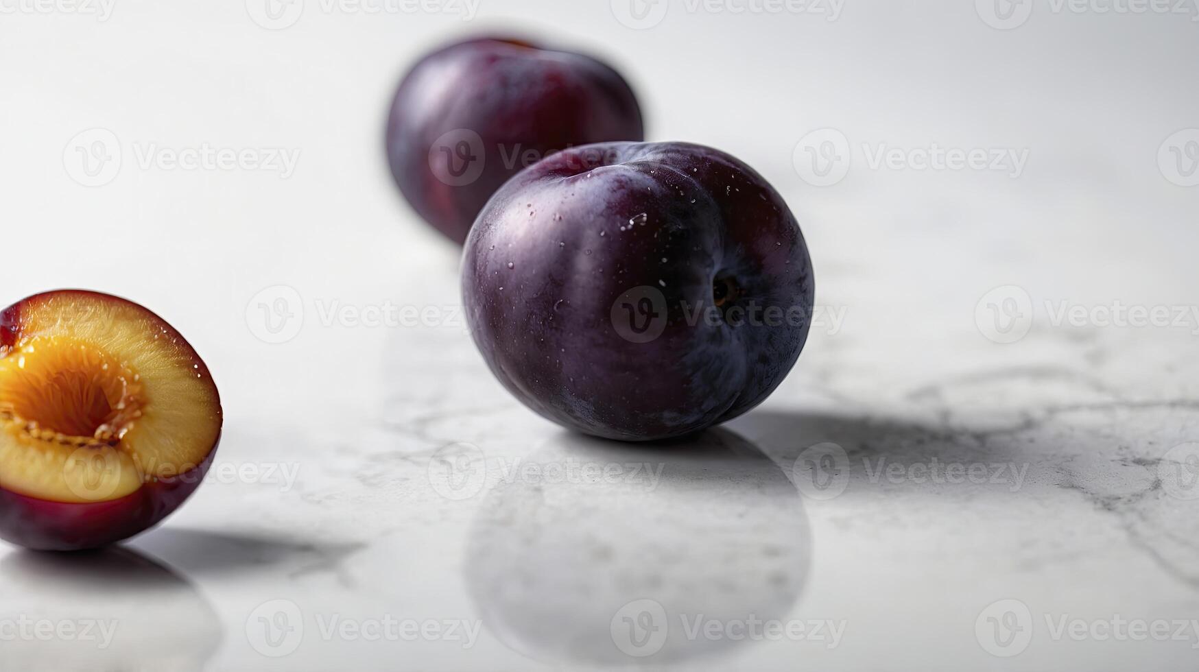 Plum Still Life Featuring Whole and Halved Fruit on Marble Surface photo