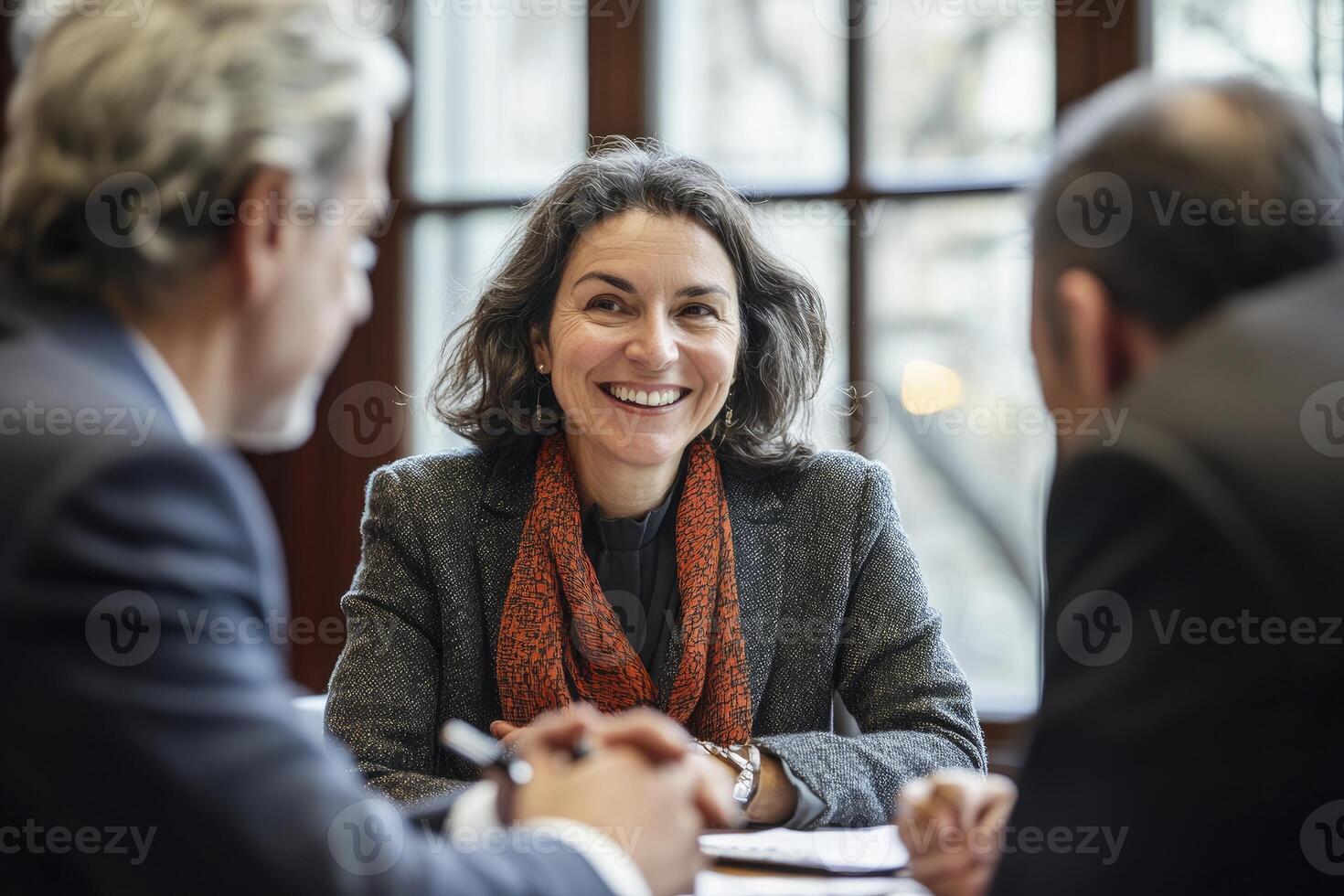 Smiling Woman Leading Business Meeting with Colleagues in Bright Office Setting photo