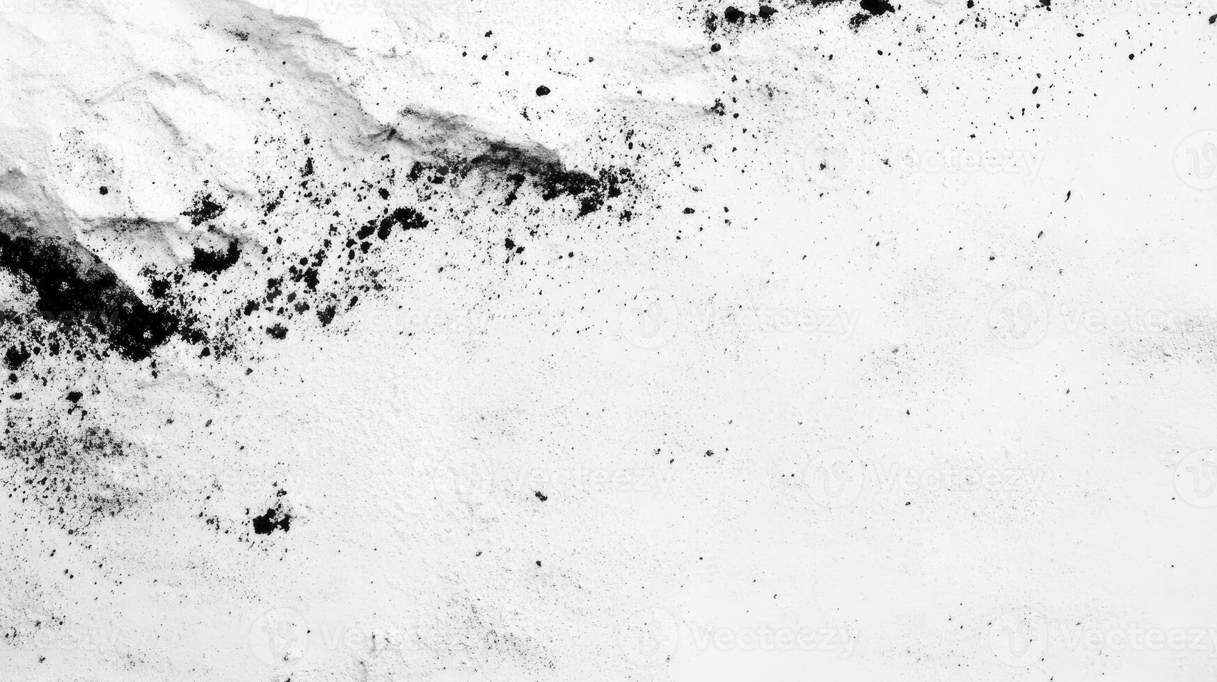 Black Powder Splatter on White Surface Creates Dramatic Abstract Texture photo