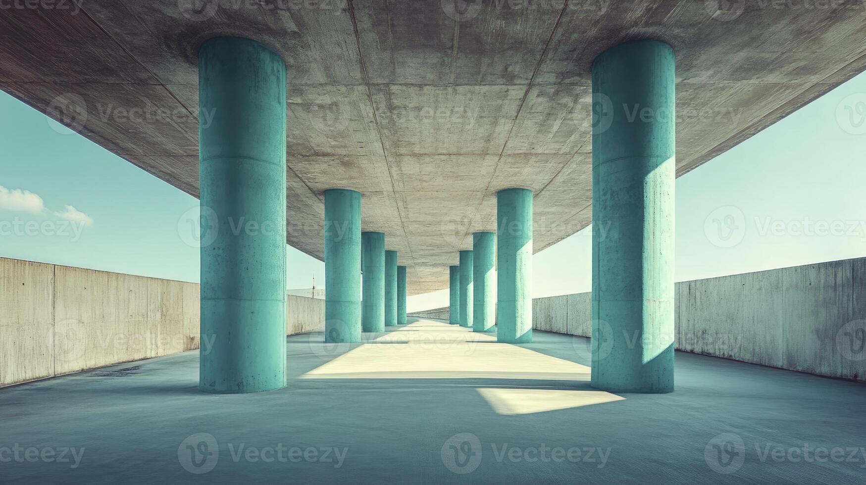 Walking Area with Repeating Teal Columns and Concrete Ceiling Overhead photo