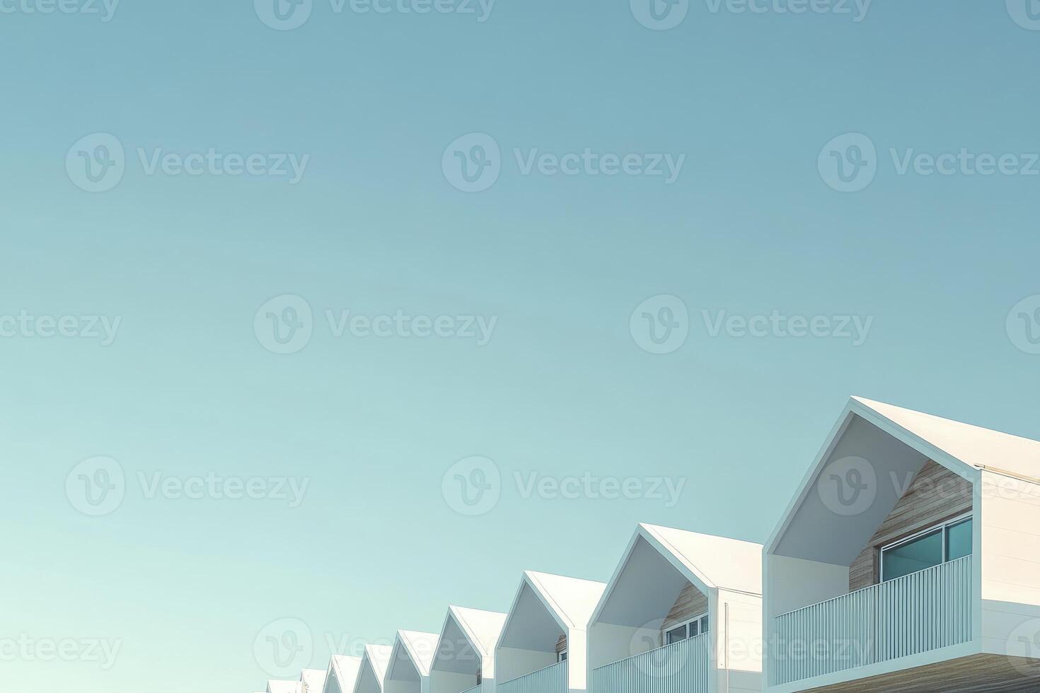 Minimalist Row of White Beach Houses Against Pale Blue Sky photo