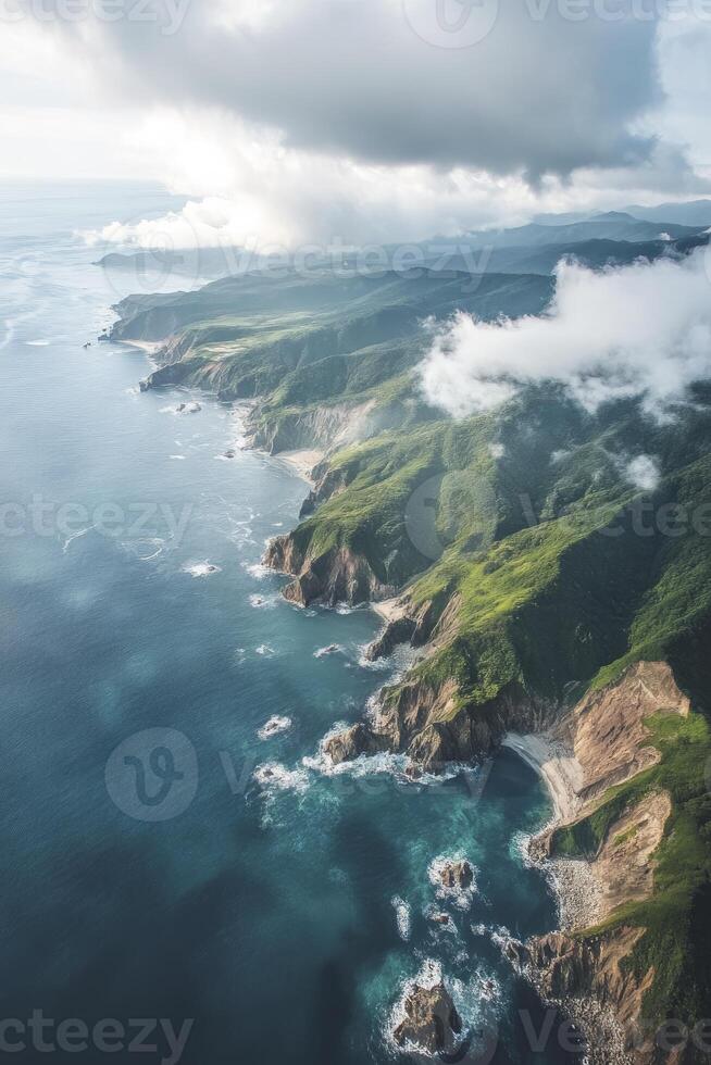 Aerial View of Rocky Coastline Meeting Turquoise Ocean with Dramatic Clouds photo
