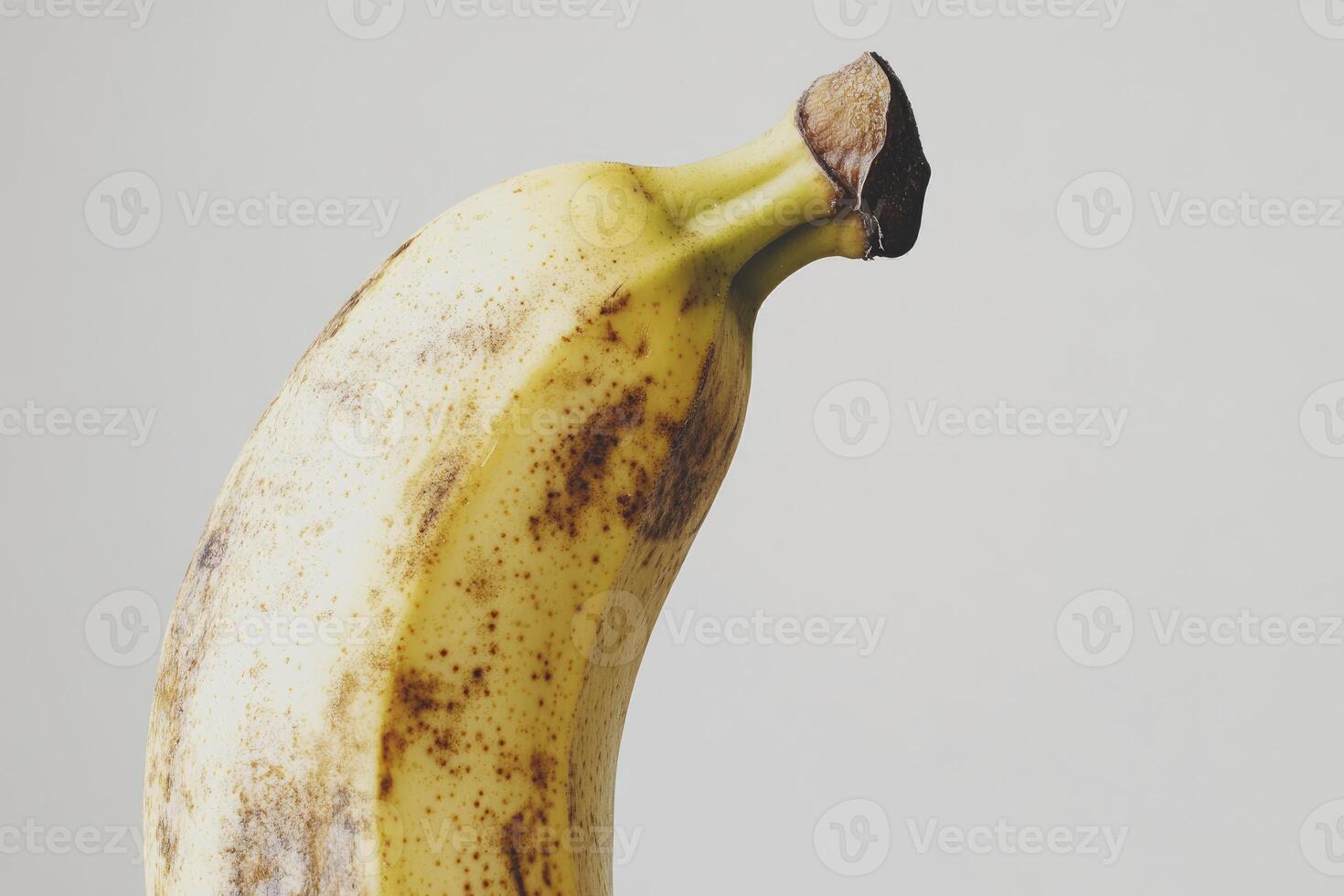 Close-up of a Ripe Banana with Brown Spots Against White Background photo