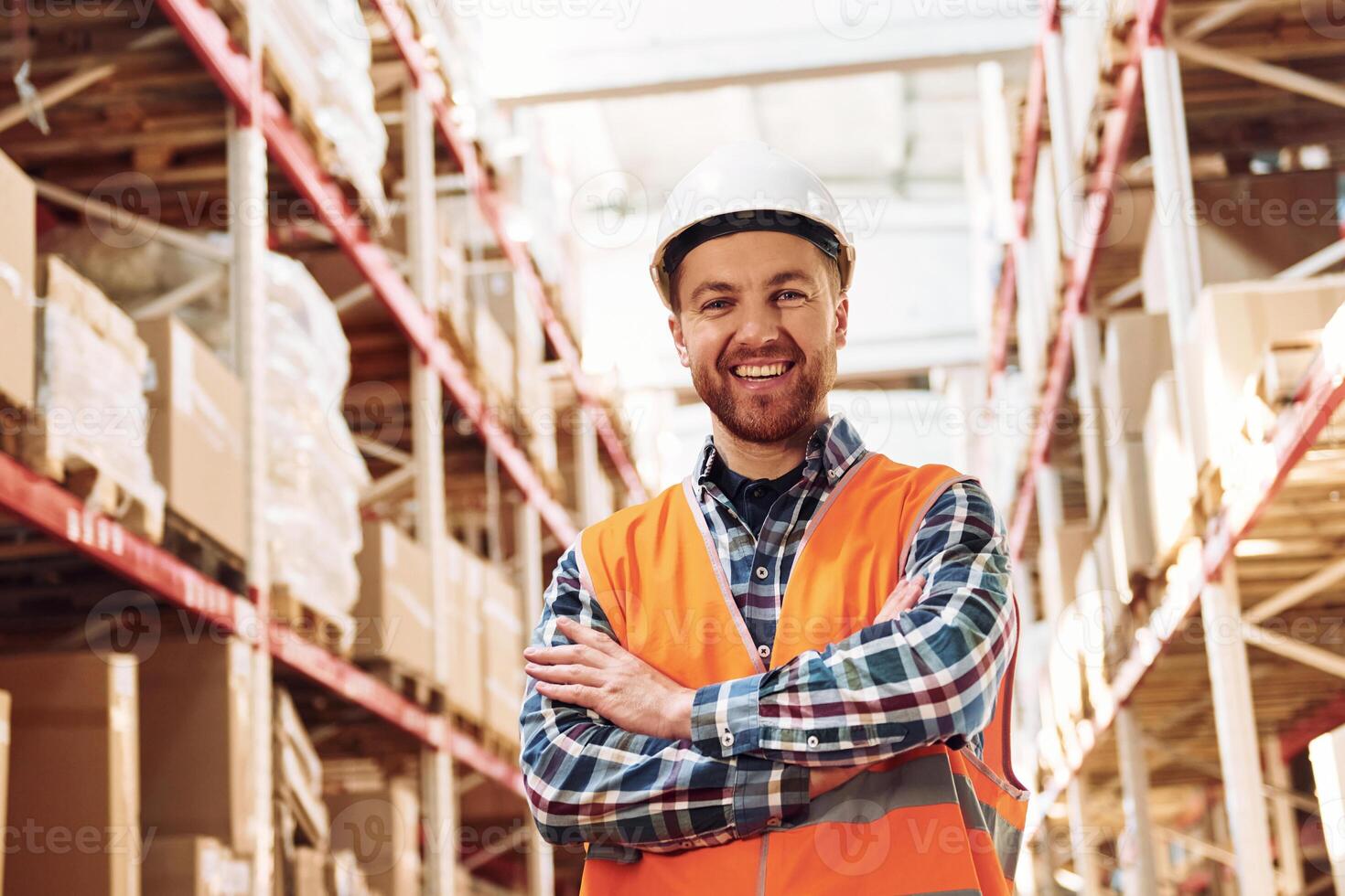 Standing with arms crossed. Employee in uniform is working in the storage at daytime photo