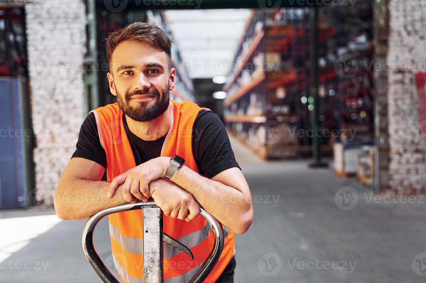 On the trolley platform. Storage worker is in the warehouse with bunch of products. photo