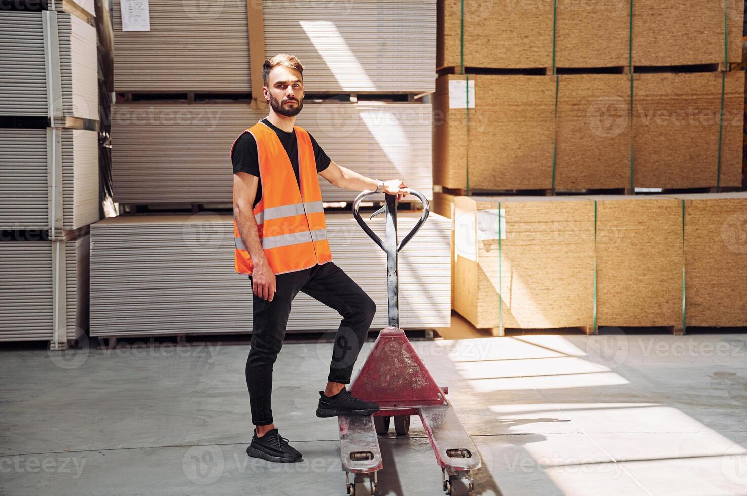 Trolley platform. .Storage worker is in the warehouse with bunch of products photo