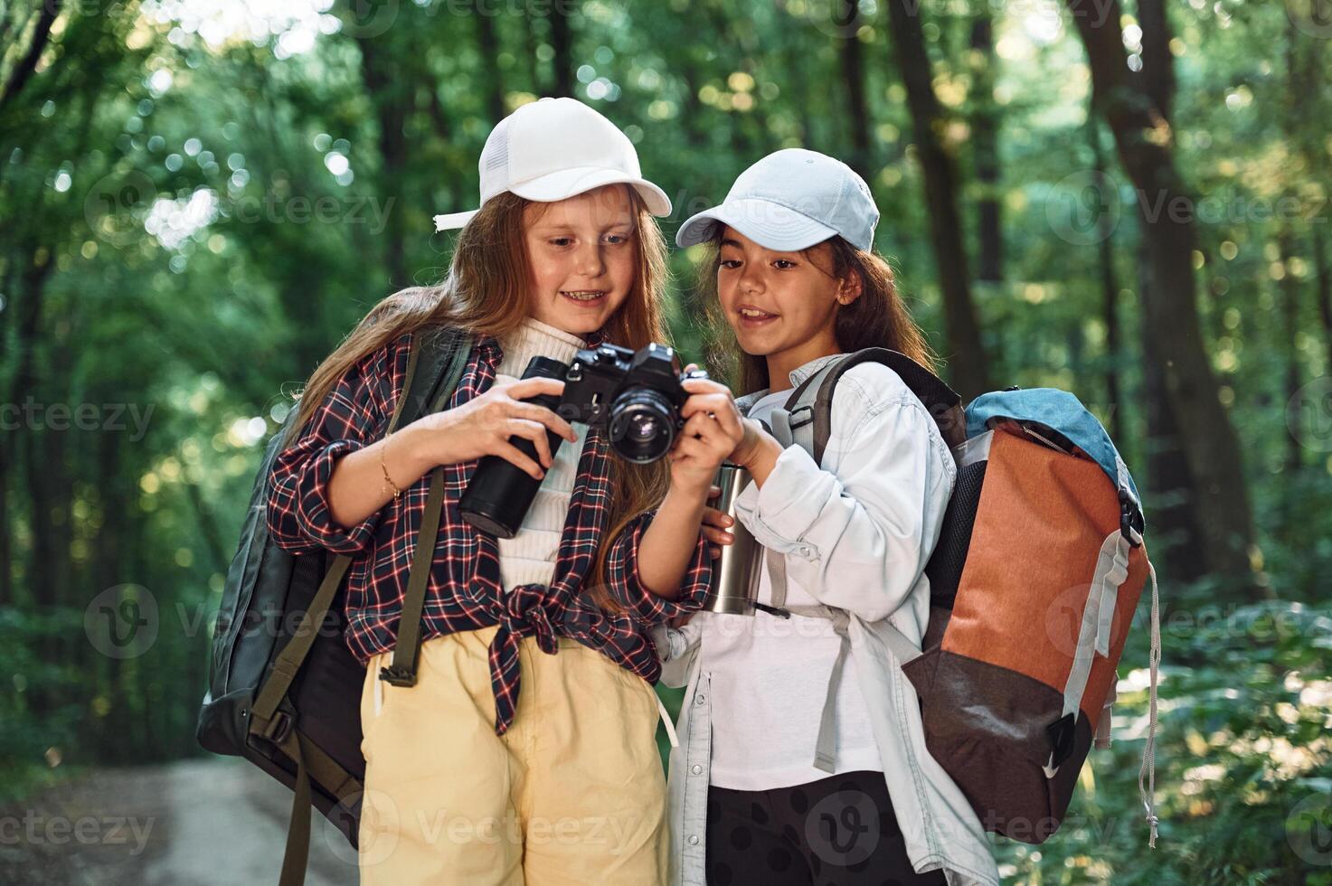 Standing, on the footpath. Two girls is in the forest having a leisure activity, discovering new places photo