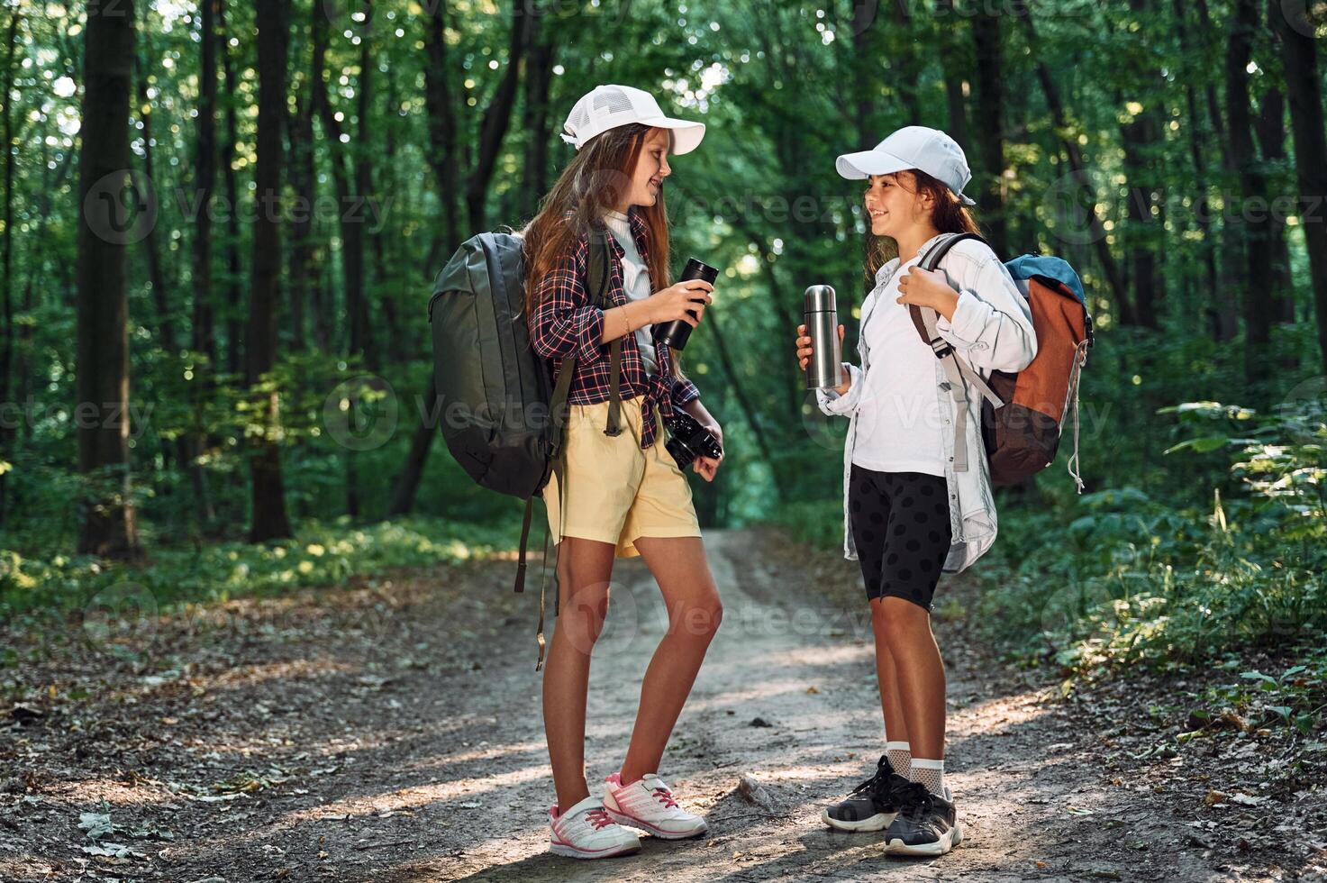 Standing on the footpath. Two girls is in the forest having a leisure activity, discovering new places photo