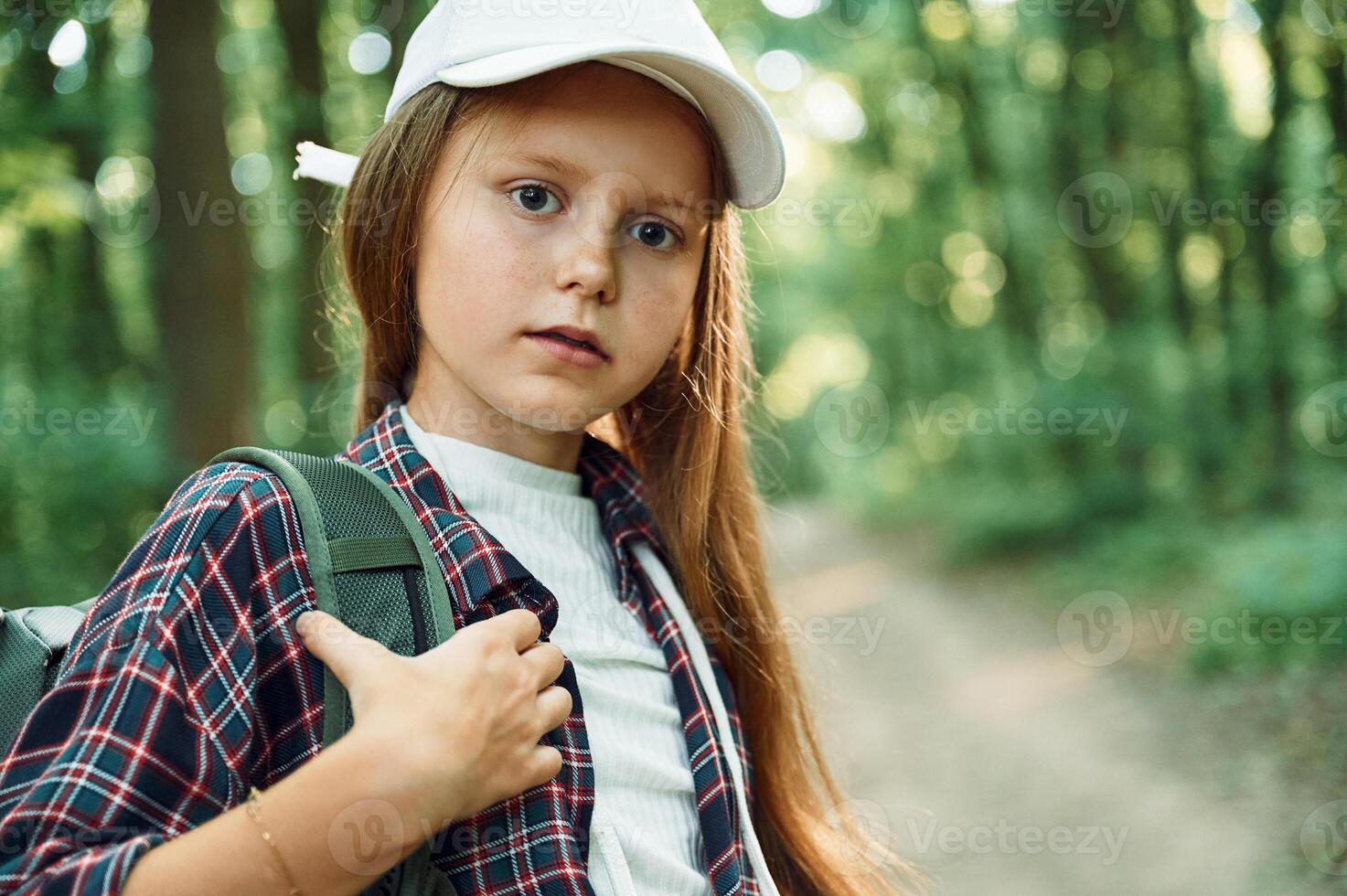 Portrait of girl that is in the forest at summer day time discovering new places photo