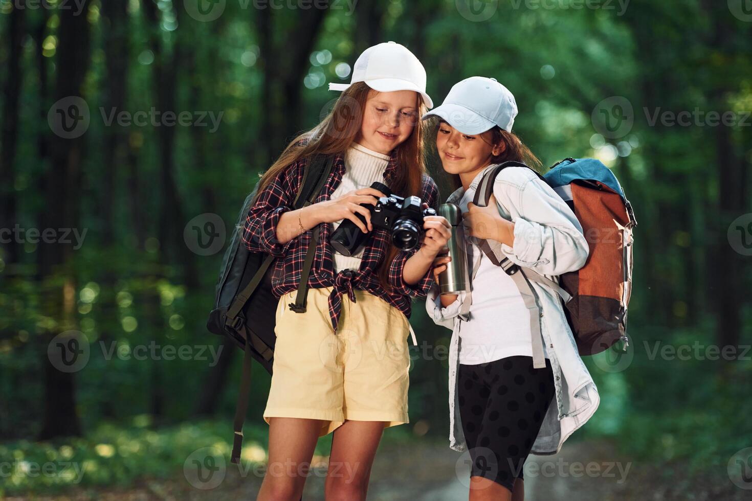 Front, view of two girls that is in the forest having a leisure activity photo