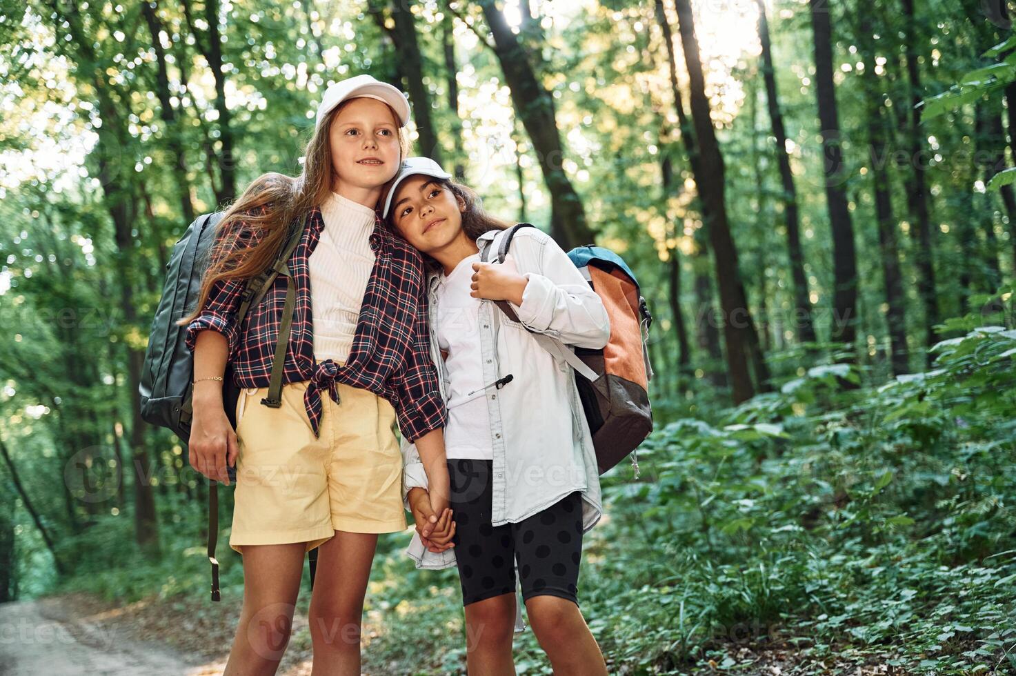 Front view. .Two girls is in the forest having a leisure activity, discovering new places photo