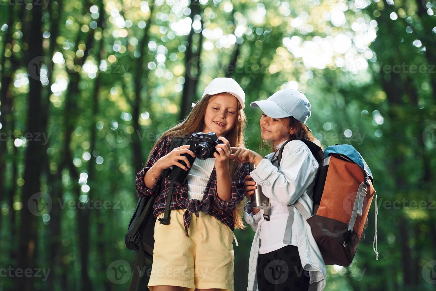 Front view of two girls that is in the forest ,having a leisure activity photo