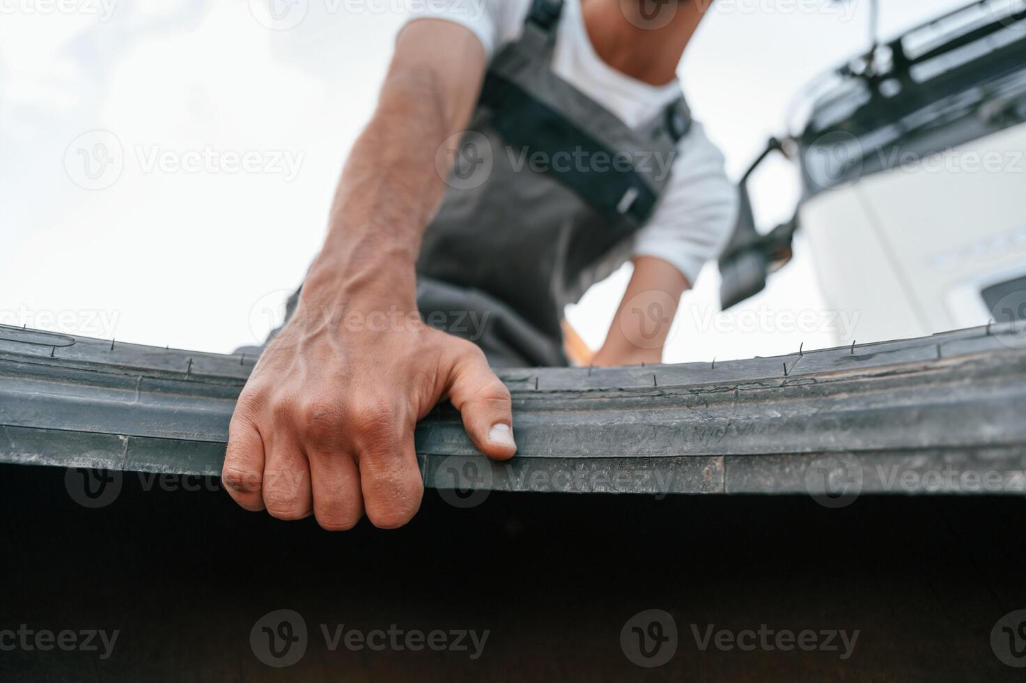 With broken tire. Man, in unifrom doing service for big truck vehicle photo