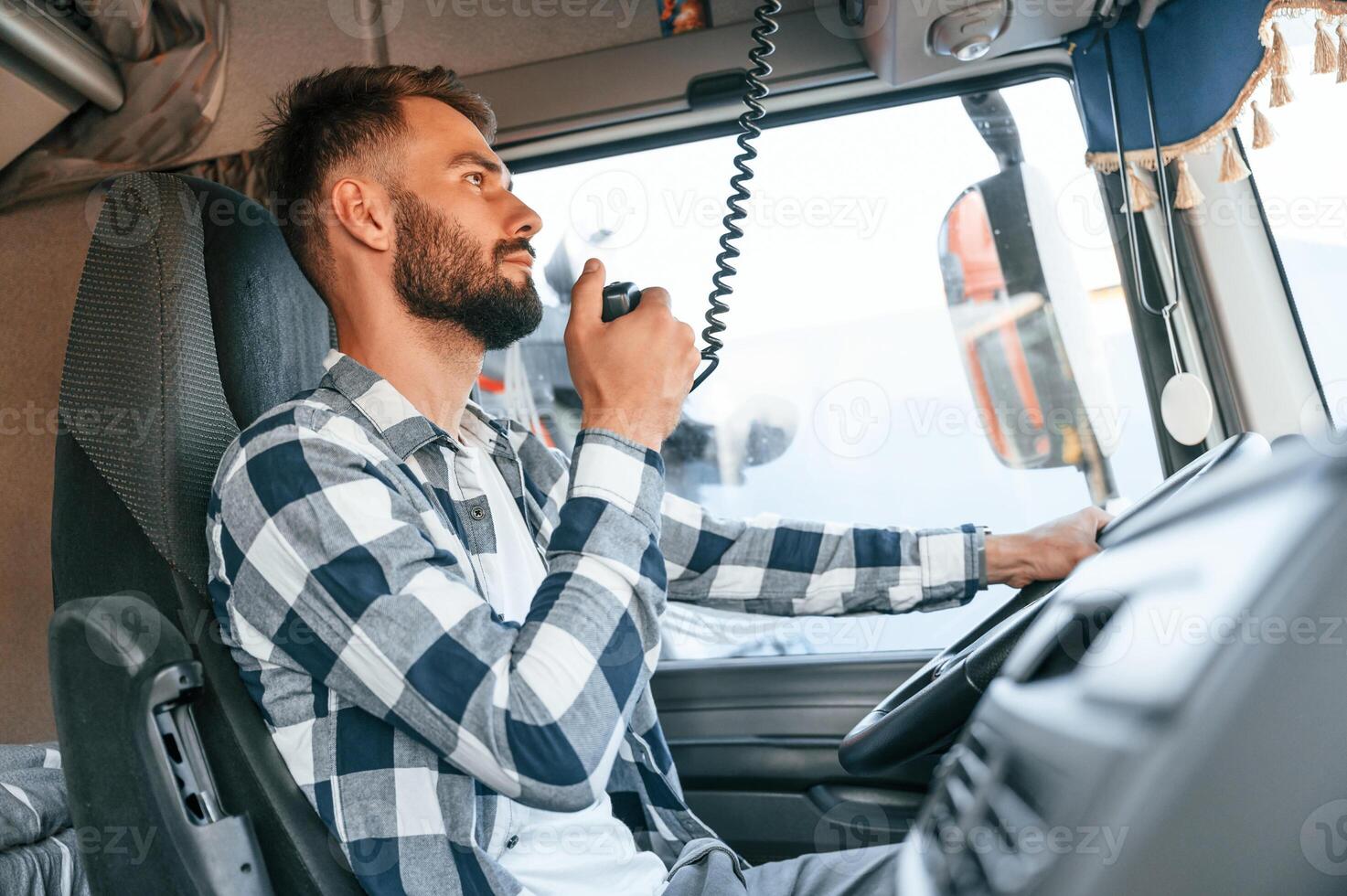 Using radio. .Young, truck driver is with his vehicle at daytime photo