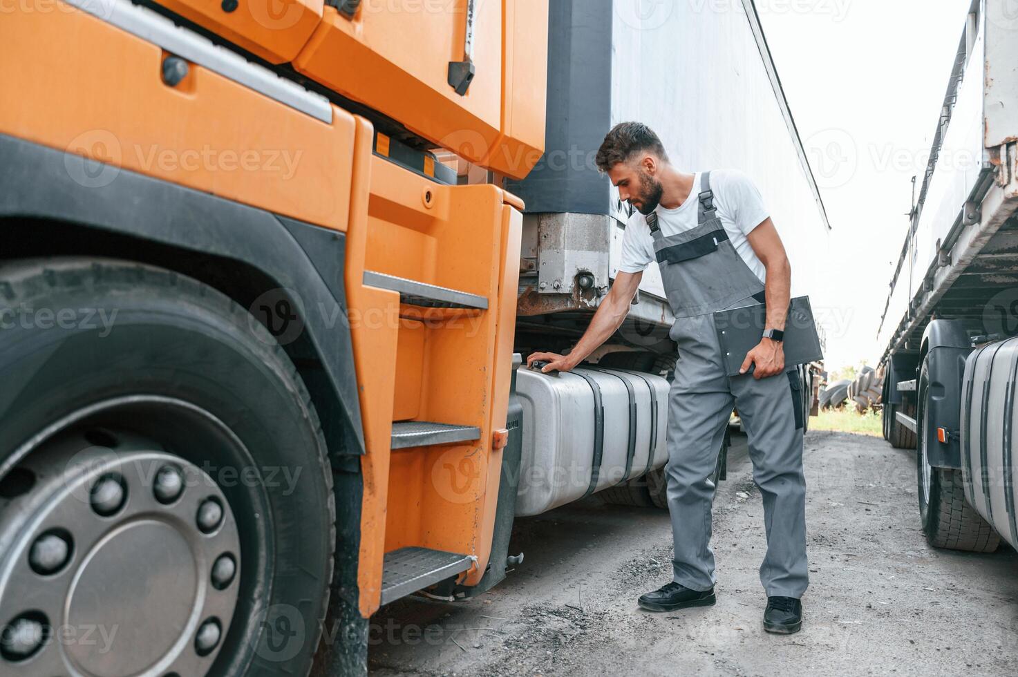 Safety check. Man in unifrom doing service for big truck vehicle photo