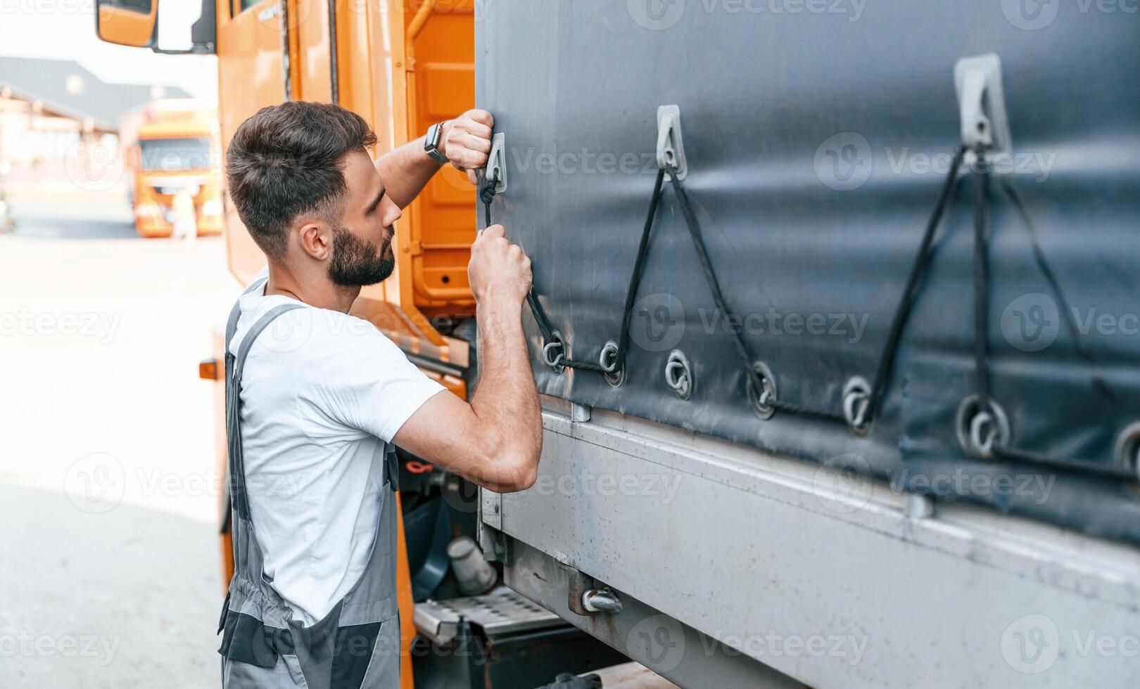 Checking the ropes. Man in unifrom doing service for big truck vehicle.. photo