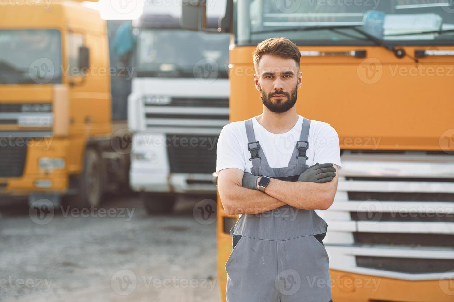 Standing, and posing for the camera. Man in unifrom doing service for big truck vehicle photo
