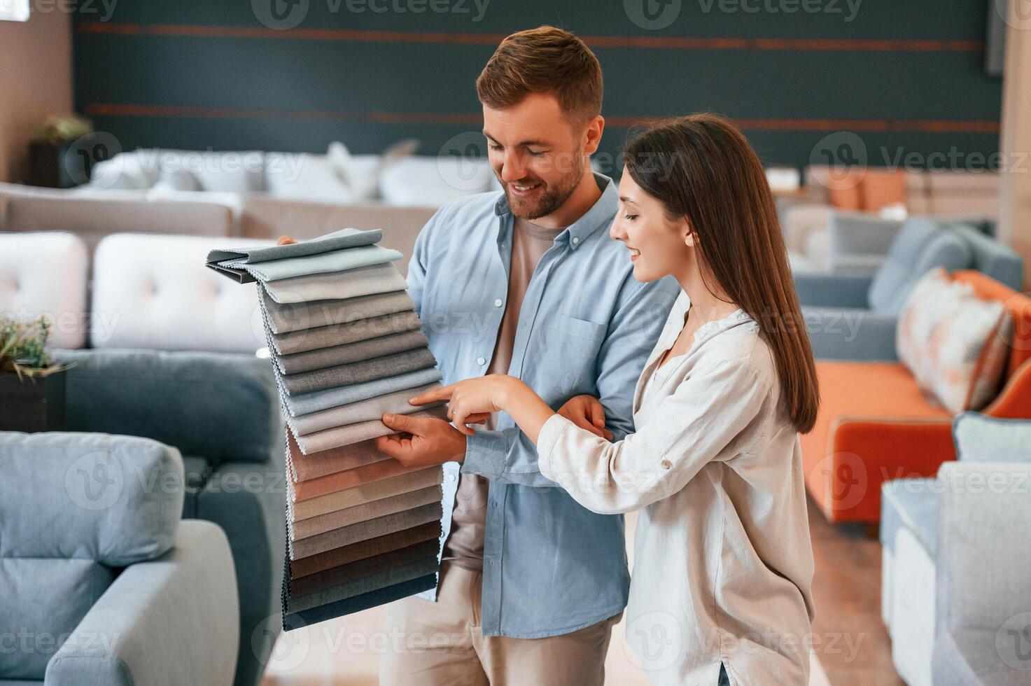 Having, fun by choosing the sofa.. Couple is in the store photo